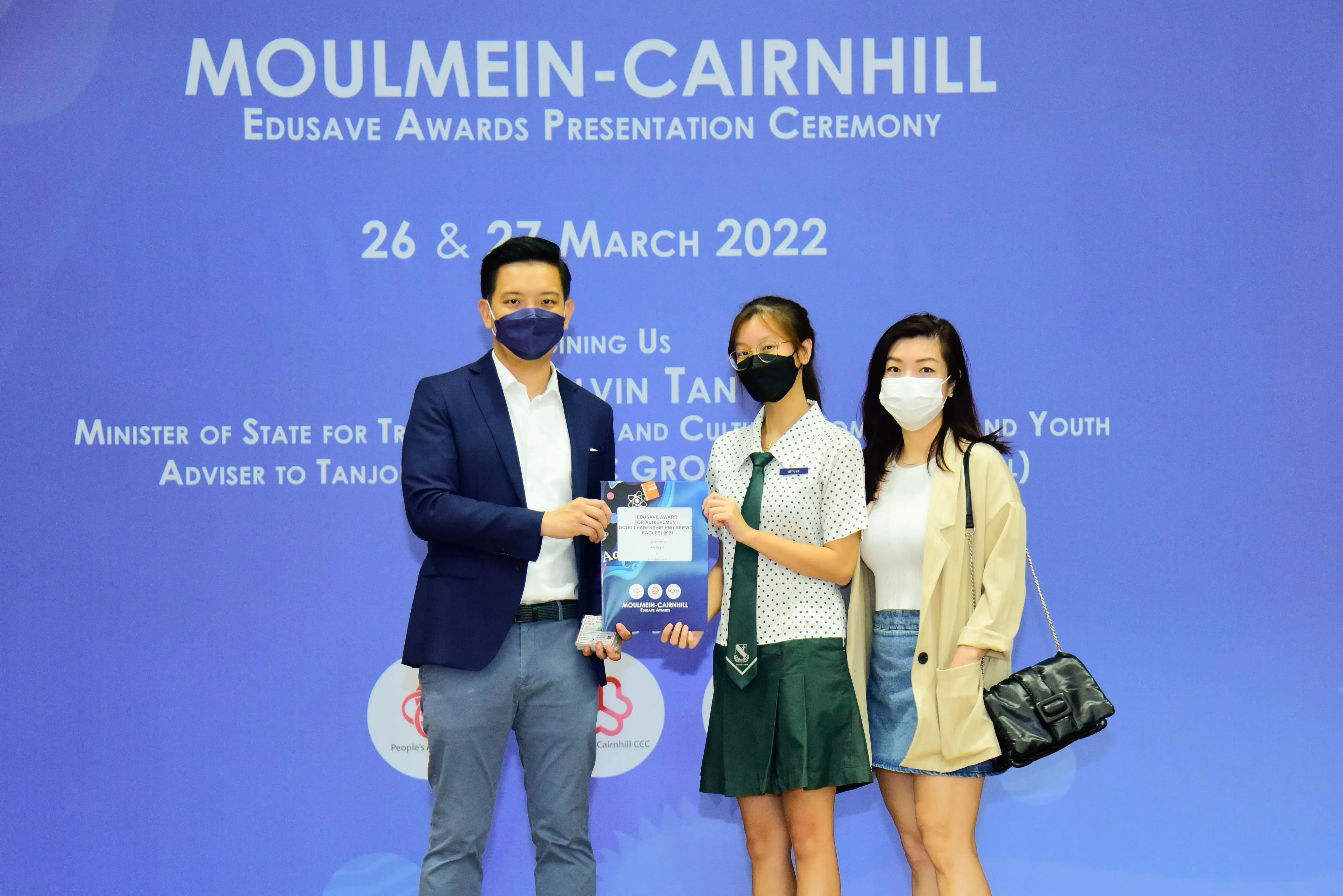 Three masked people pose at the Moulmein-Cairnhill Edusave Awards Presentation Ceremony on 26-27 March 2022.