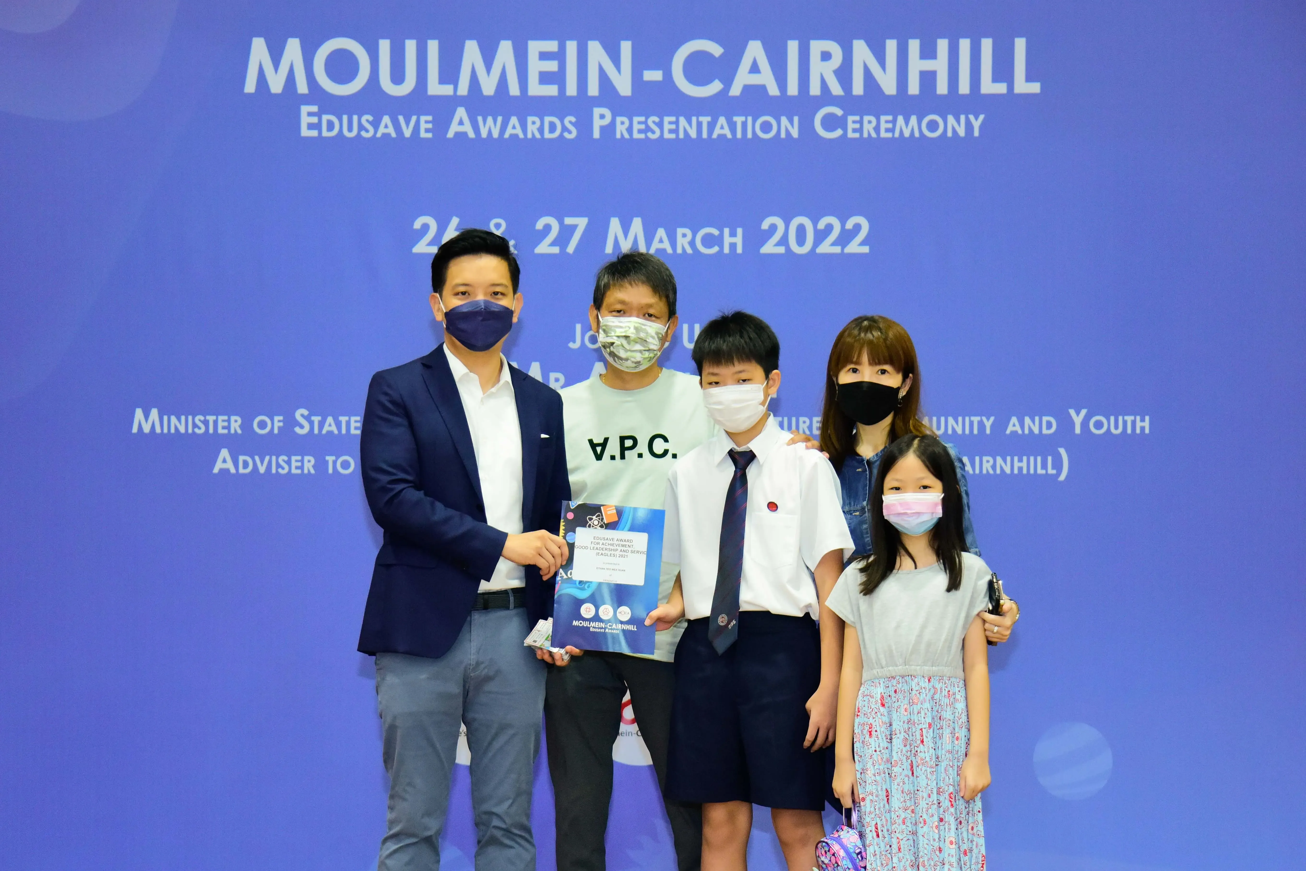 Five masked people pose at the Moulmein-Cairnhill Edusave Awards Presentation Ceremony on 26-27 March 2022.