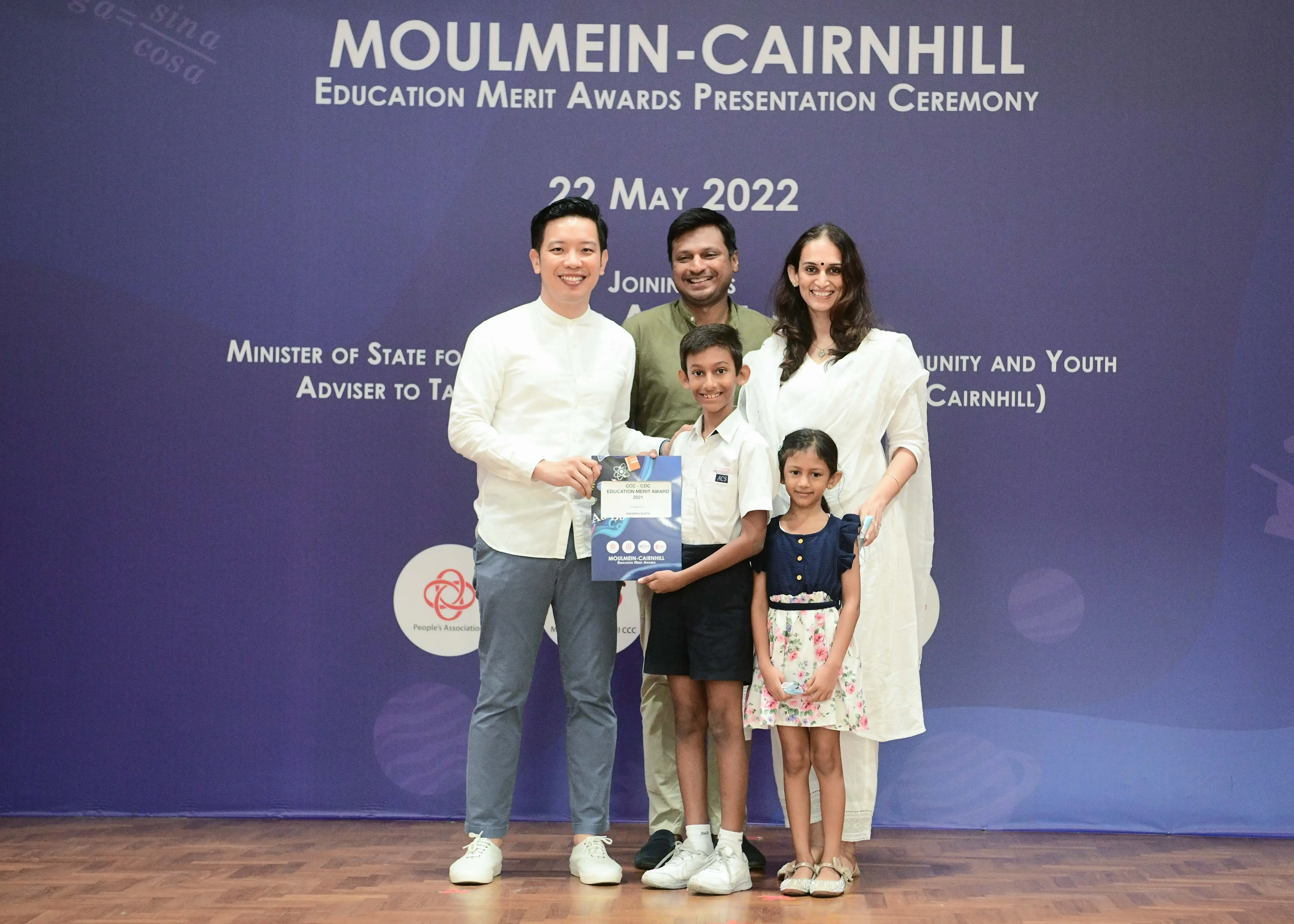 Five people pose with an award certificate at the Moulmein-Cairnhill Education Merit Awards Ceremony on 22 May 2022.