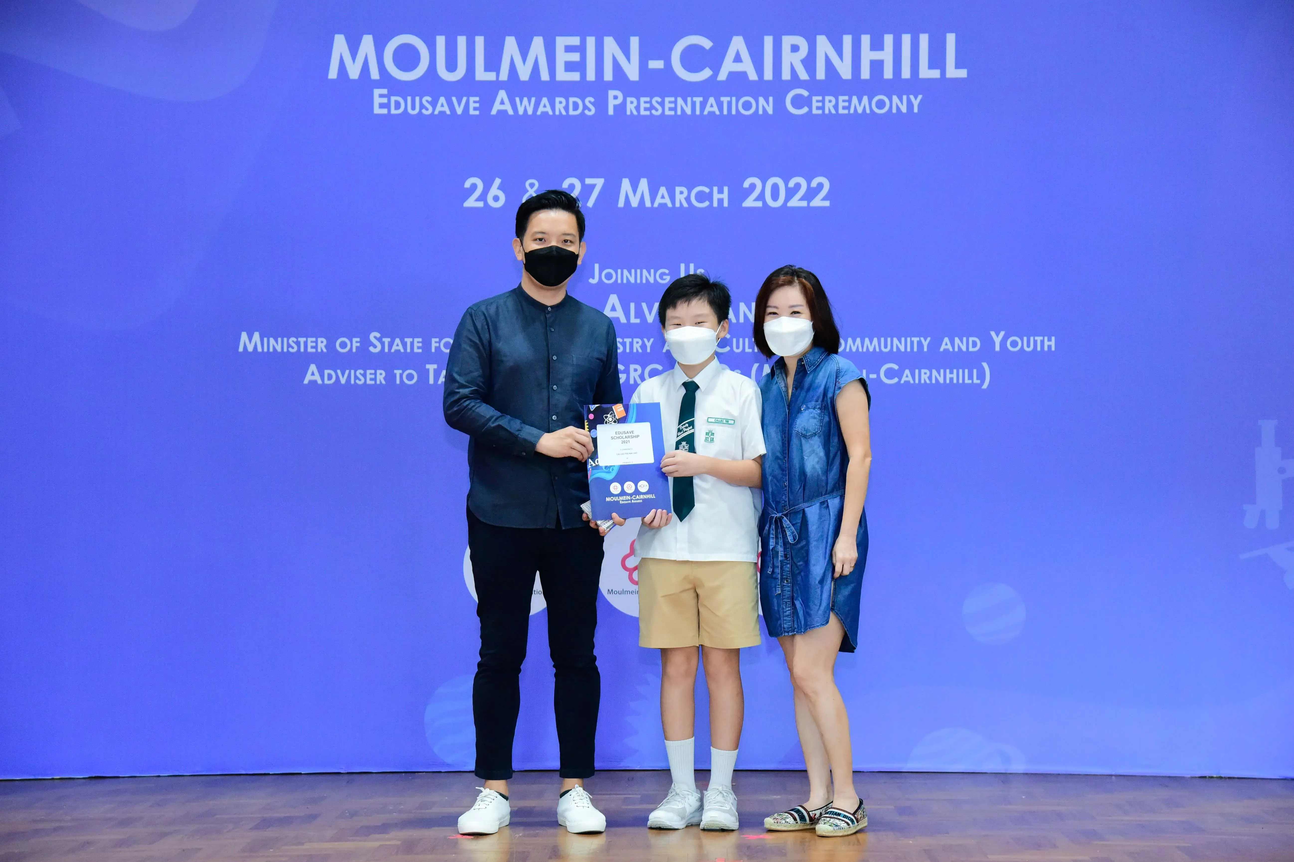 Three masked people pose at the Moulmein-Cairnhill Edusave Awards Ceremony on 26-27 March 2022.