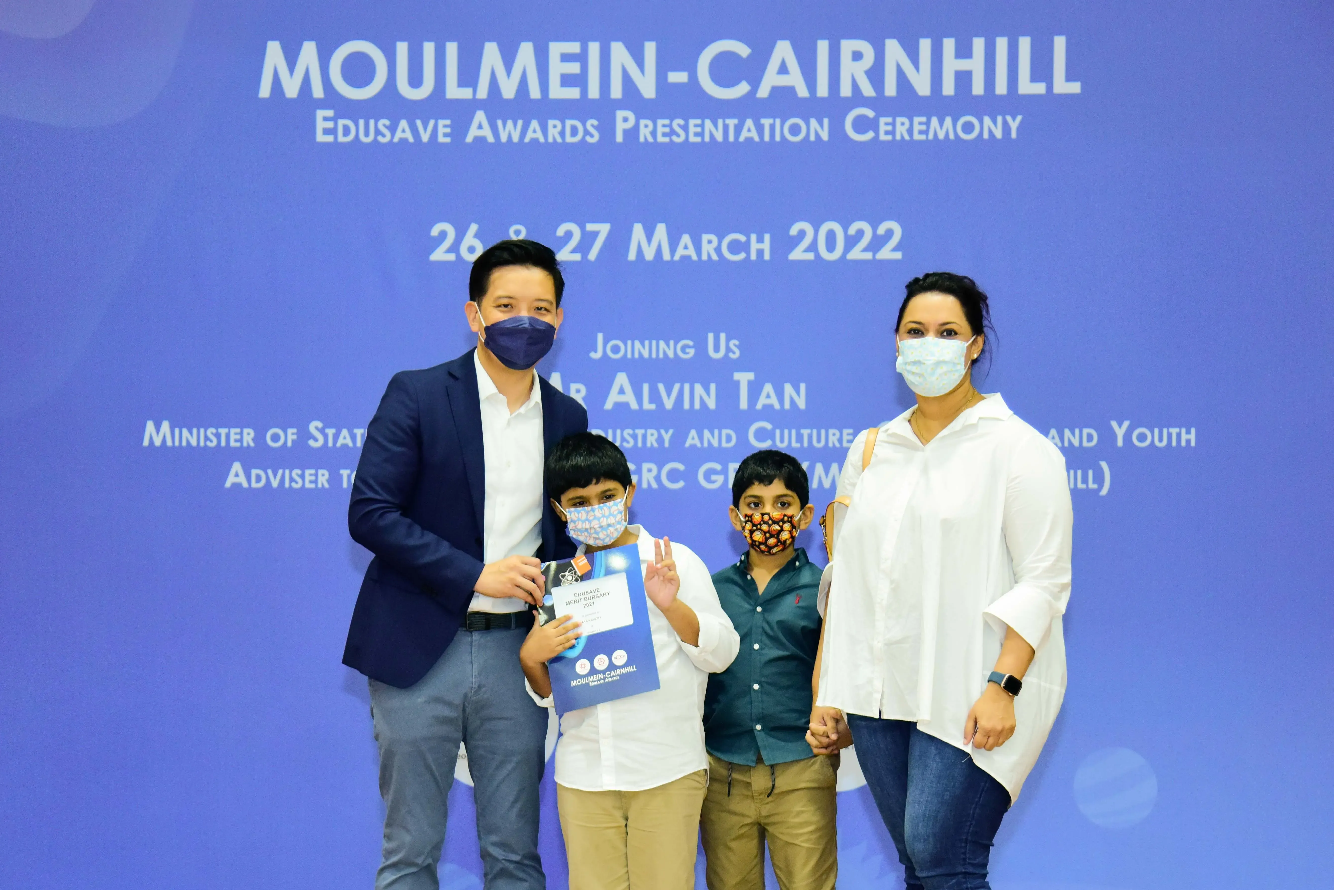 Four masked people pose at the Moulmein-Cairnhill Edusave Awards Ceremony on 26-27 March 2022.