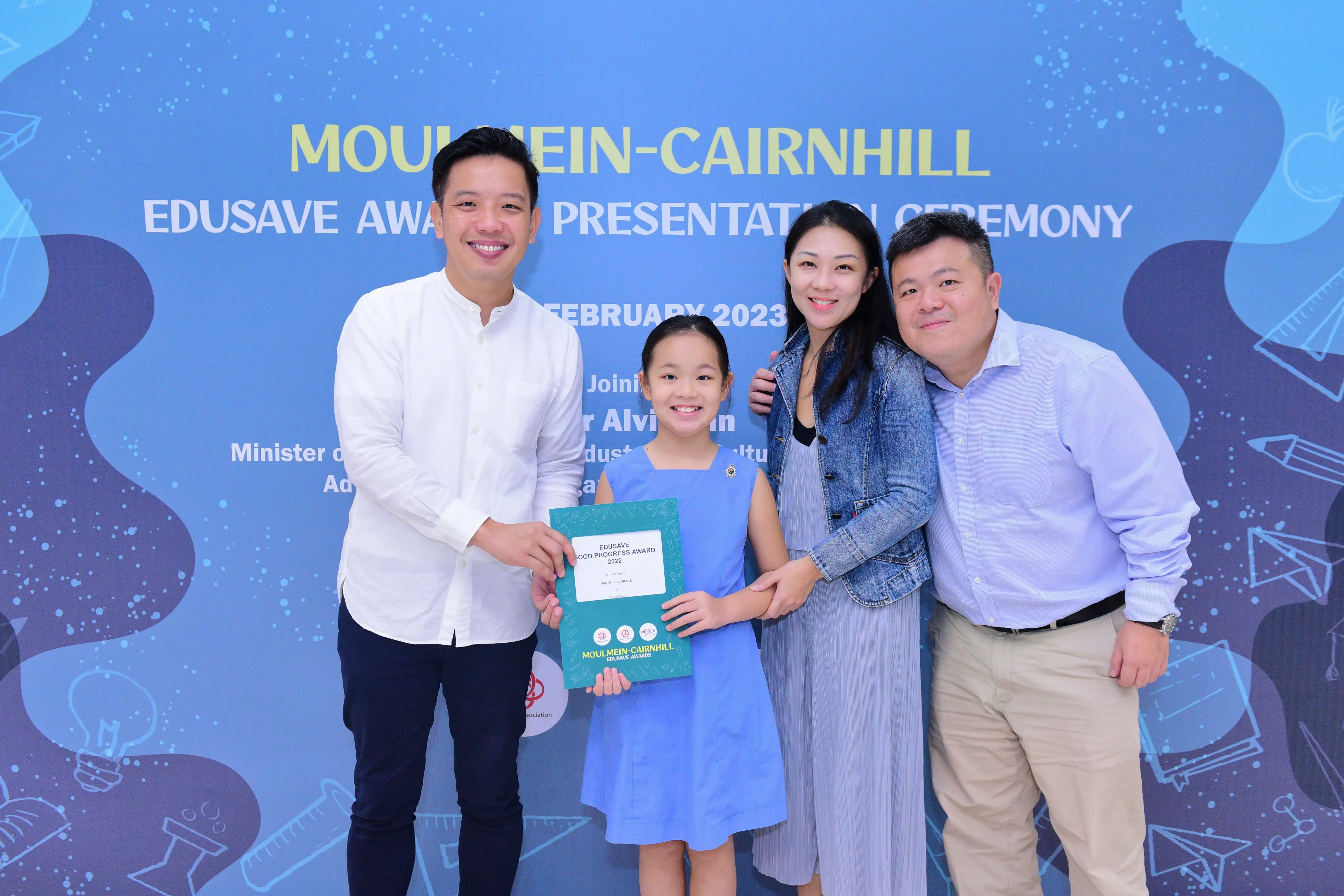 Four people pose with a certificate at the Moulmein-Cairnhill Edusave Award Presentation Ceremony in February 2023.
