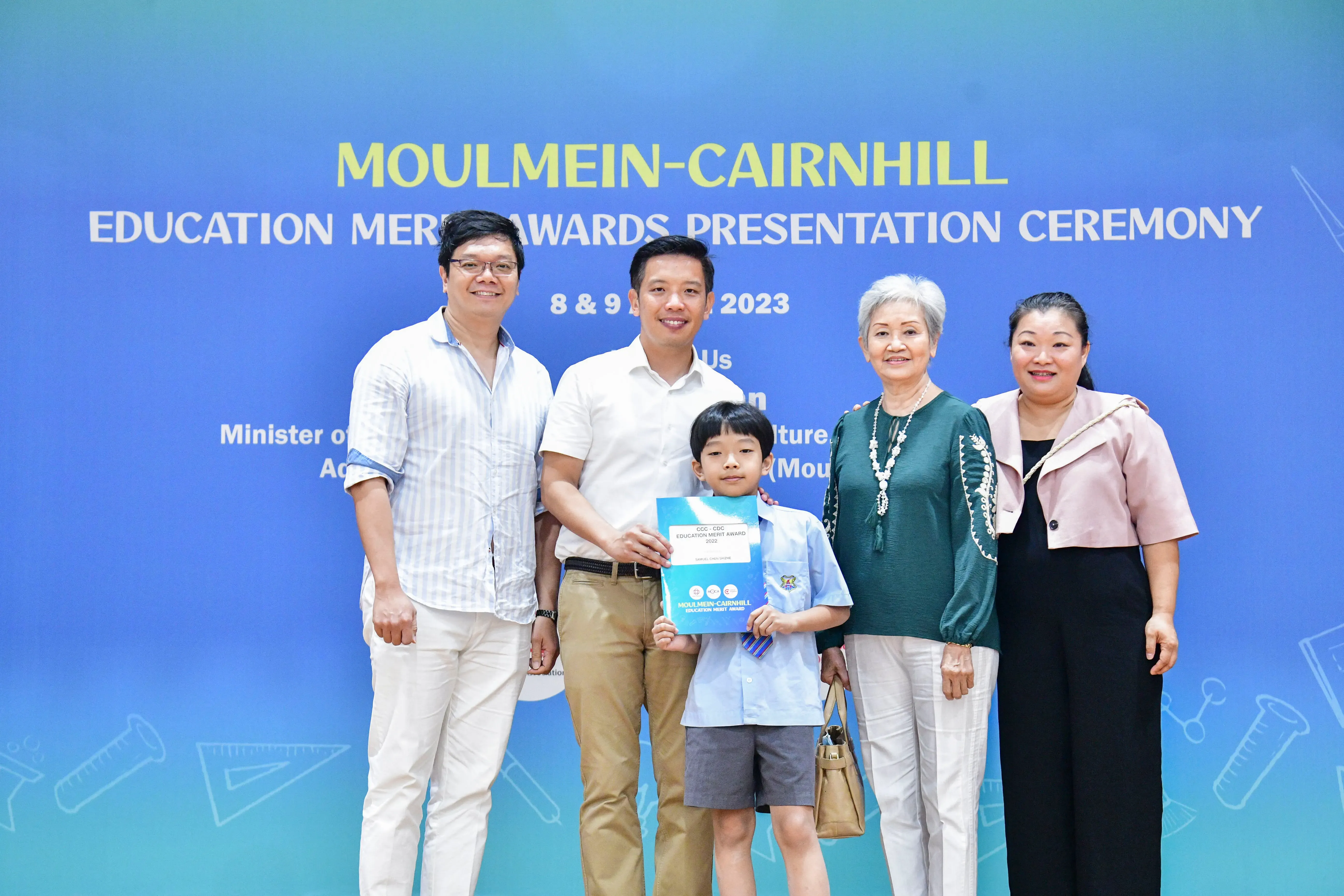 Four adults and a young boy pose at the Moulmein-Cairnhill Education Merit Awards Presentation Ceremony 2023.