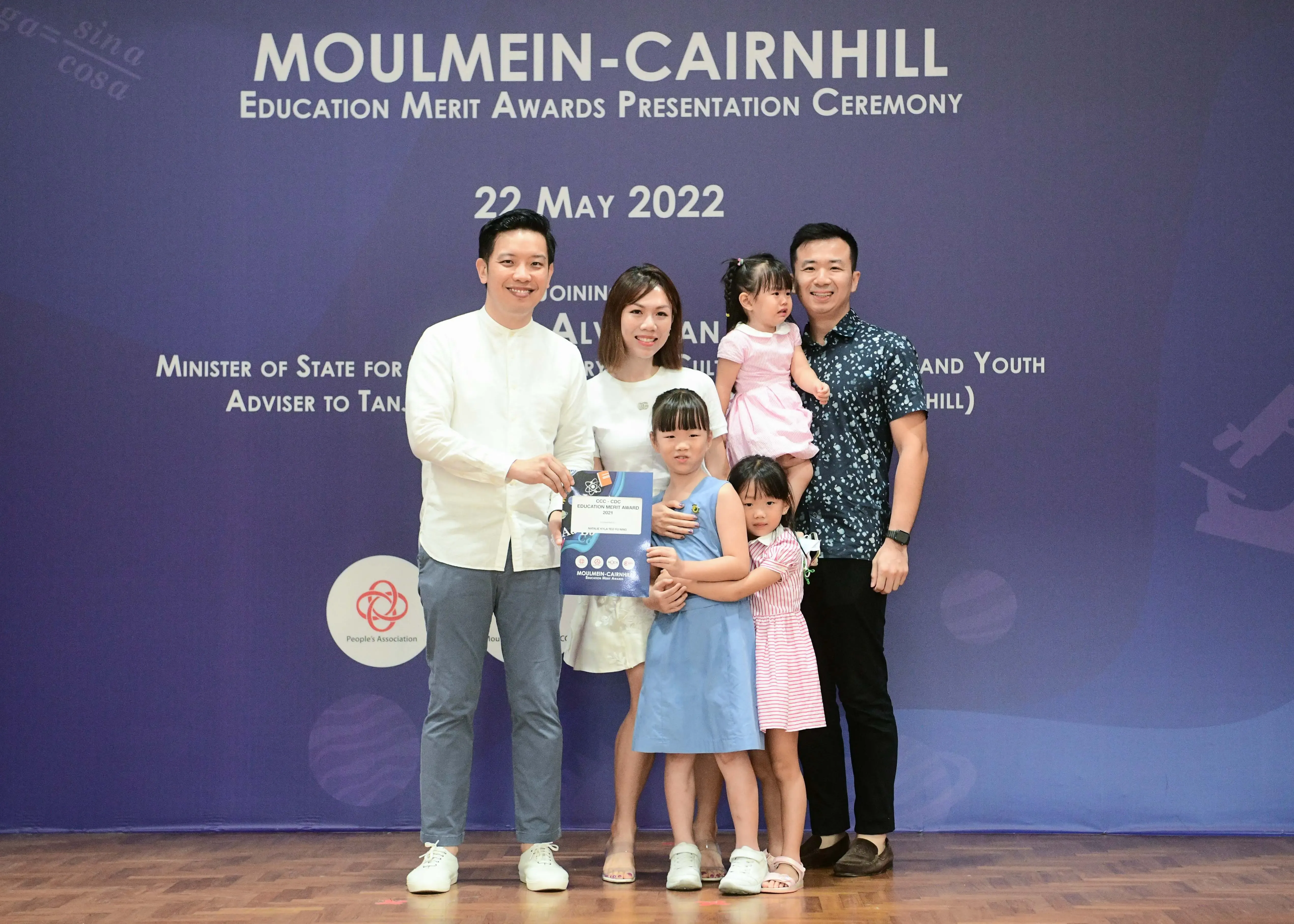 Two adults and three young children pose at the Moulmein-Cairnhill Education Merit Awards ceremony on 22 May 2022.