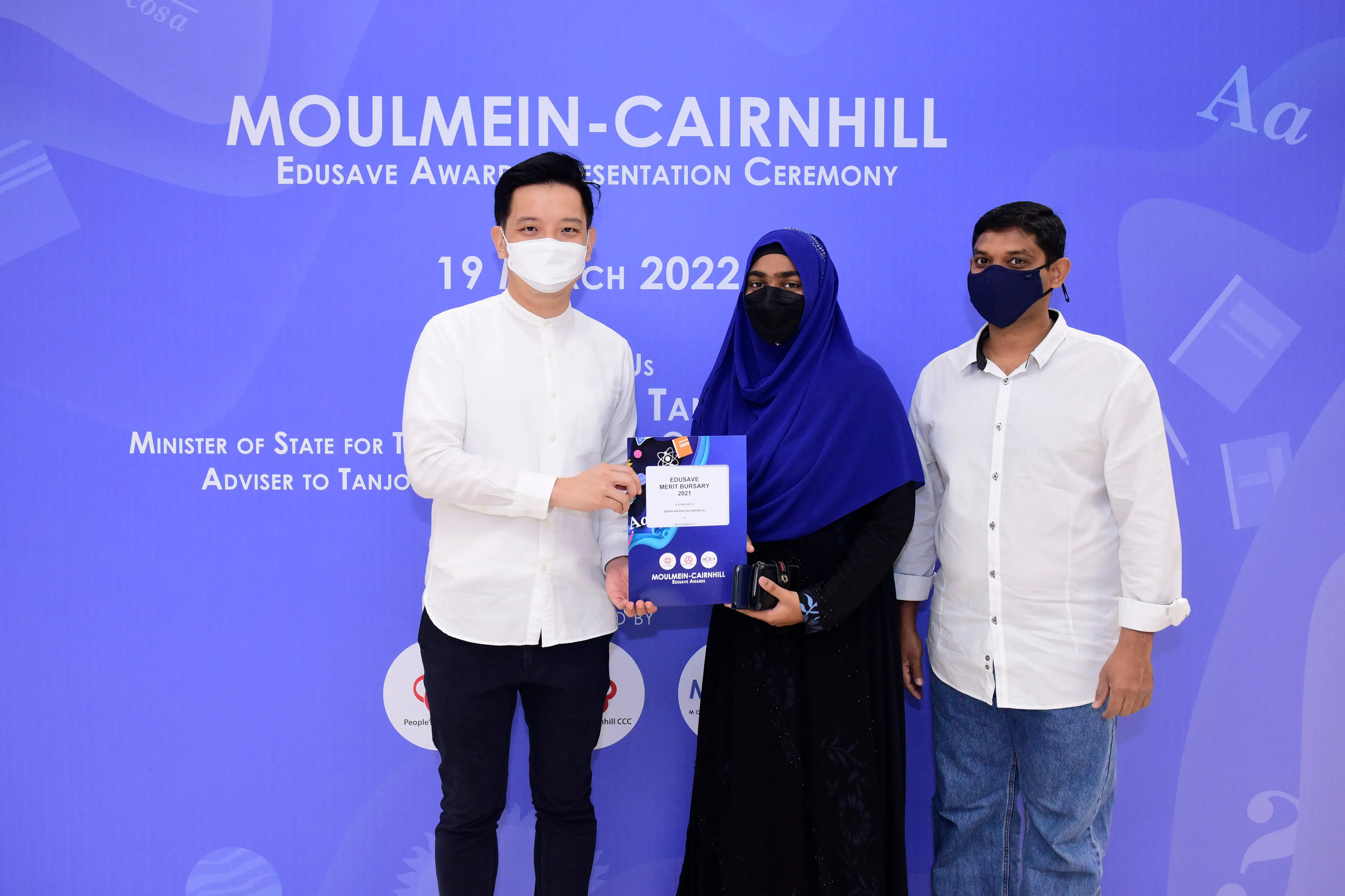 Three masked people pose at the Moulmein-Cairnhill Edusave Award Presentation Ceremony on 19 March 2022.