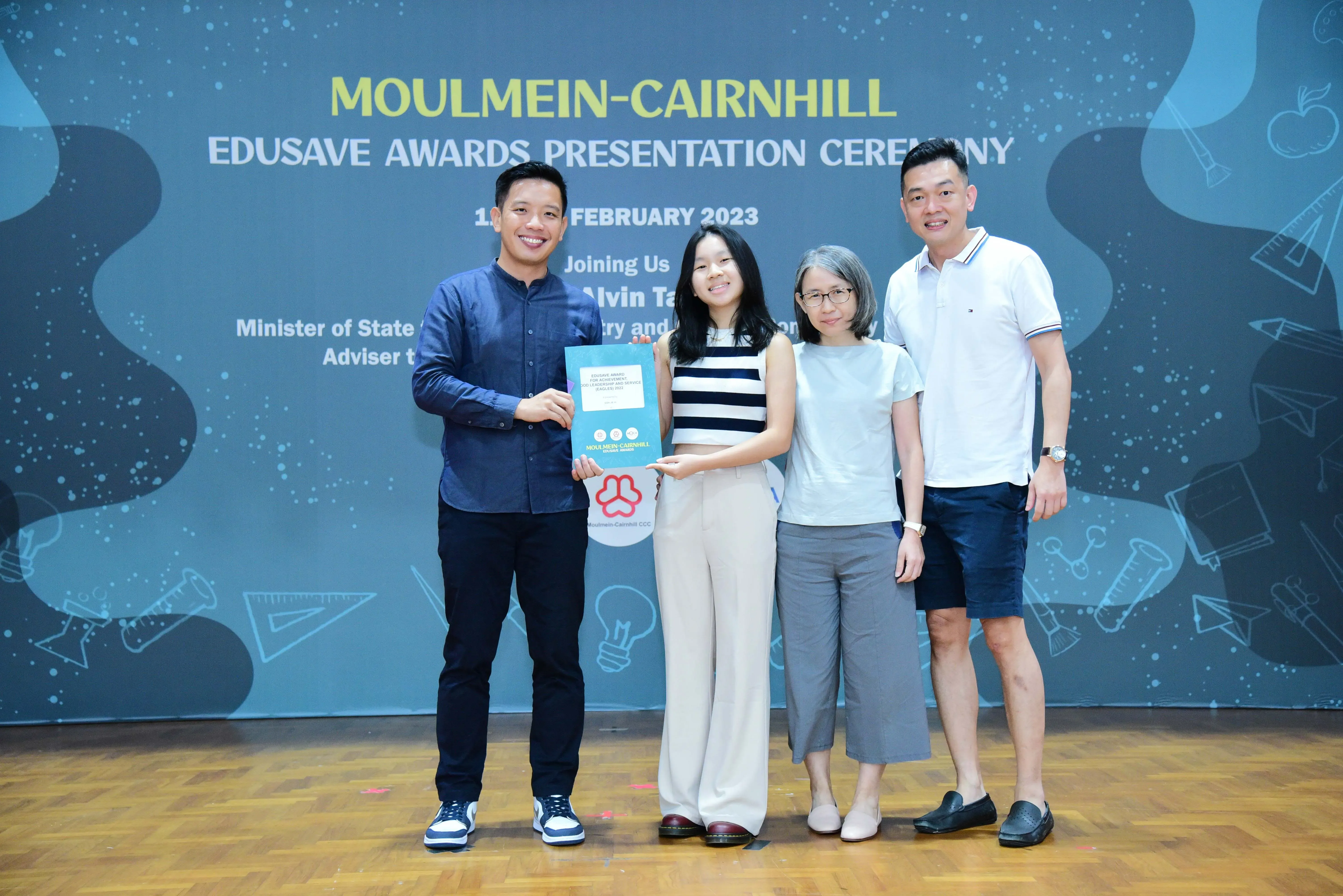 Four people pose with an award certificate at the Moulmein-Cairnhill Edusave Awards Presentation Ceremony, February 2023.