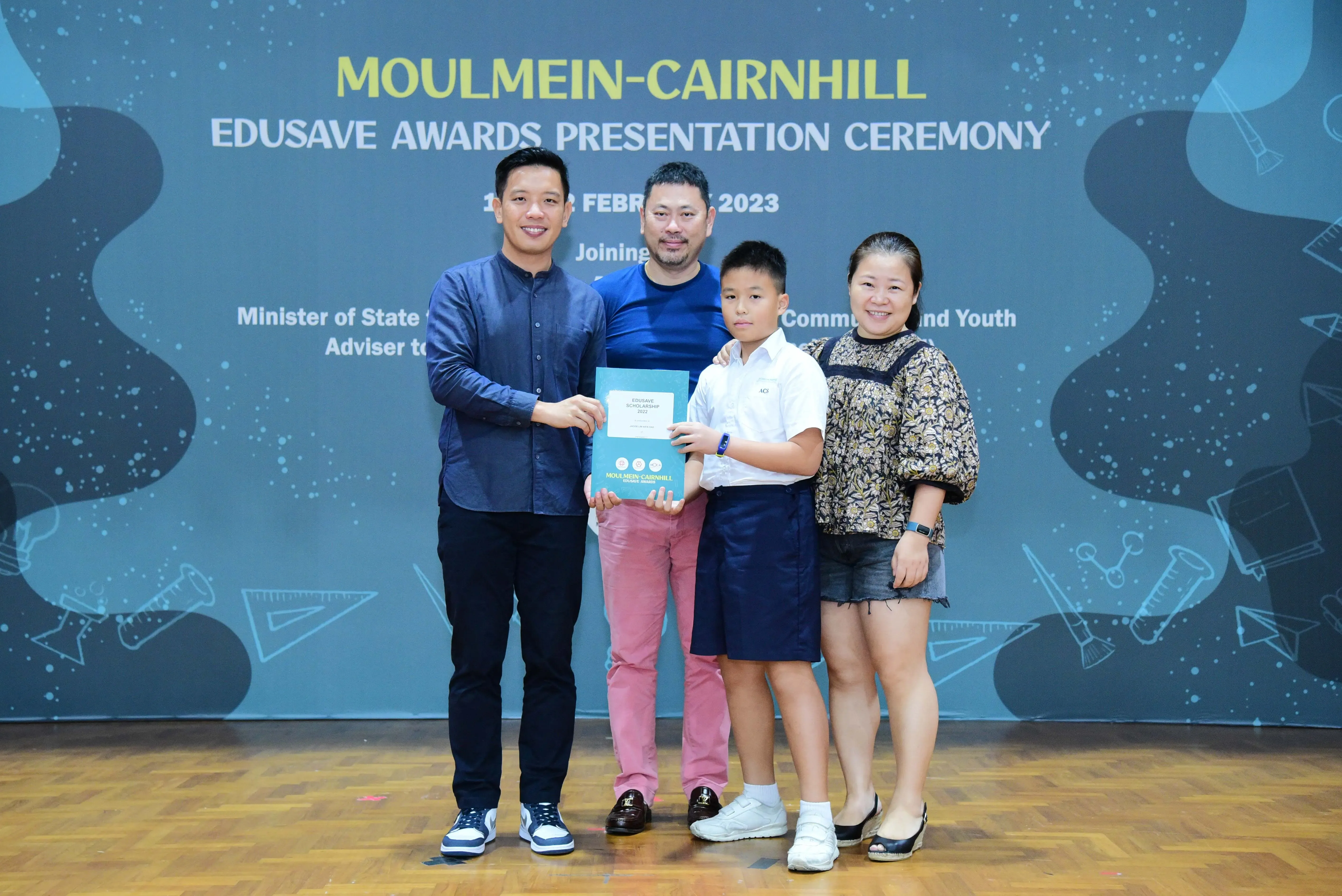 Four people pose with an award certificate at the Moulmein-Cairnhill Edusave Awards Presentation Ceremony 2023.