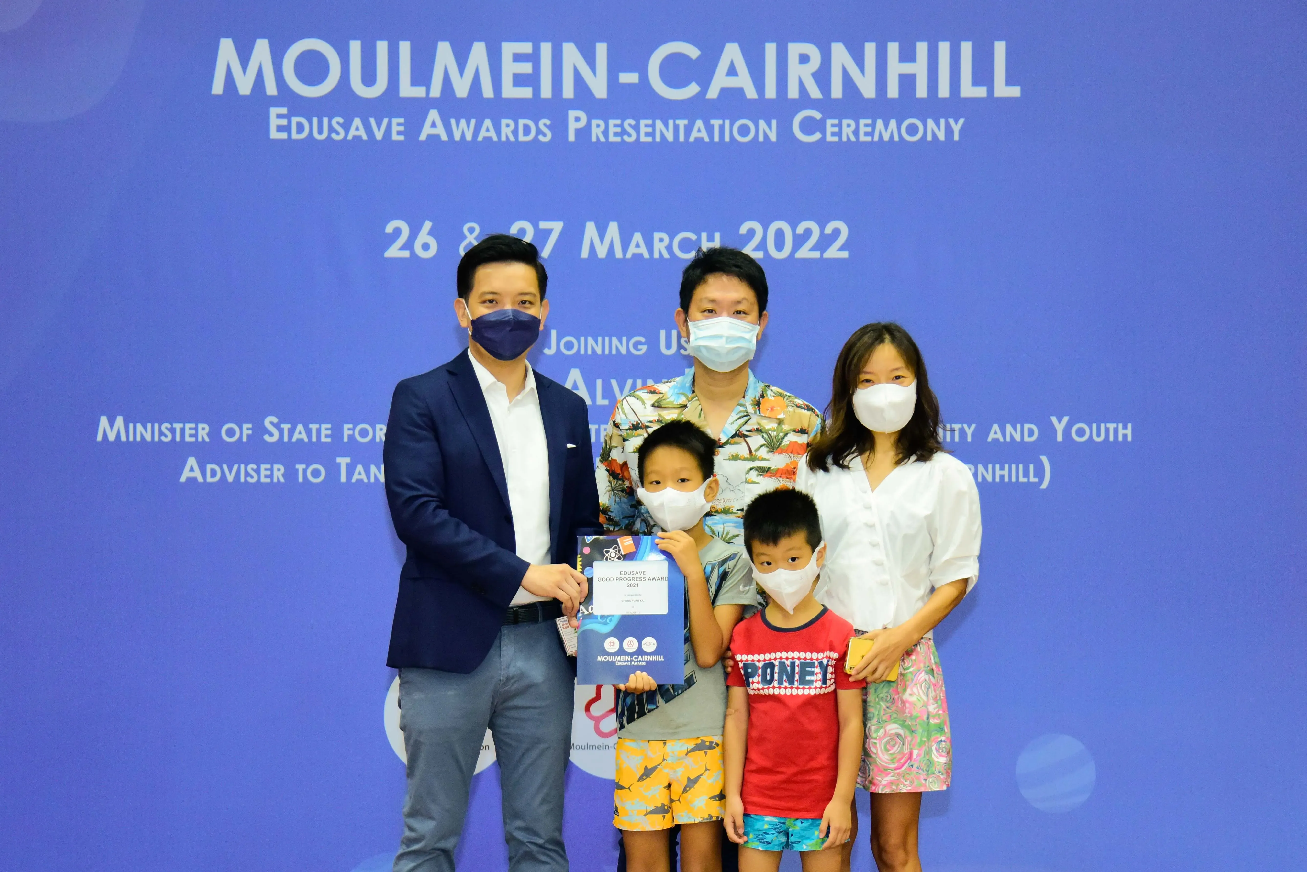Five masked people pose at the Moulmein-Cairnhill Edusave Awards Presentation Ceremony on 26-27 March 2022.