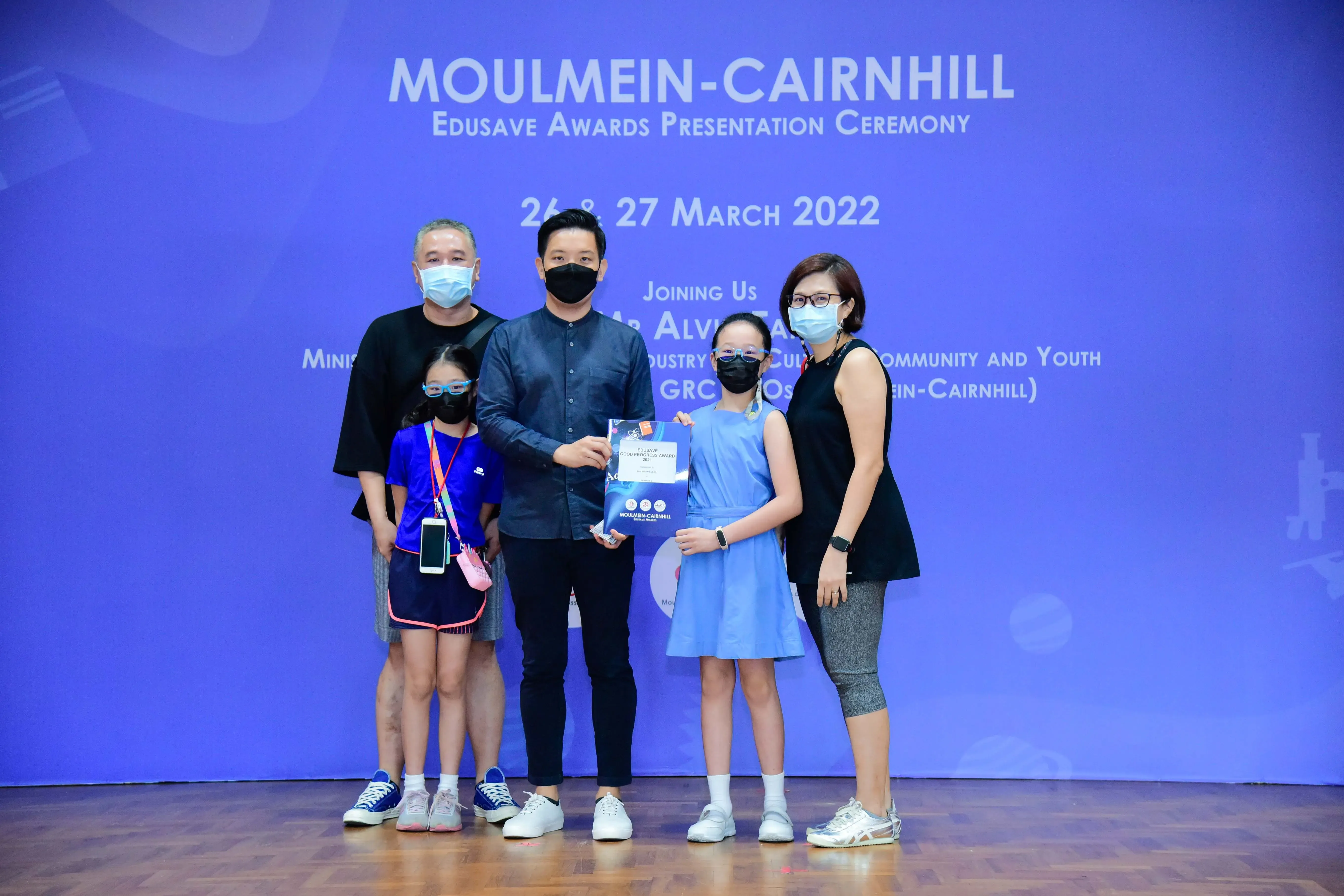 Five masked people pose at the Moulmein-Cairnhill Edusave Awards Presentation Ceremony on March 26-27, 2022.