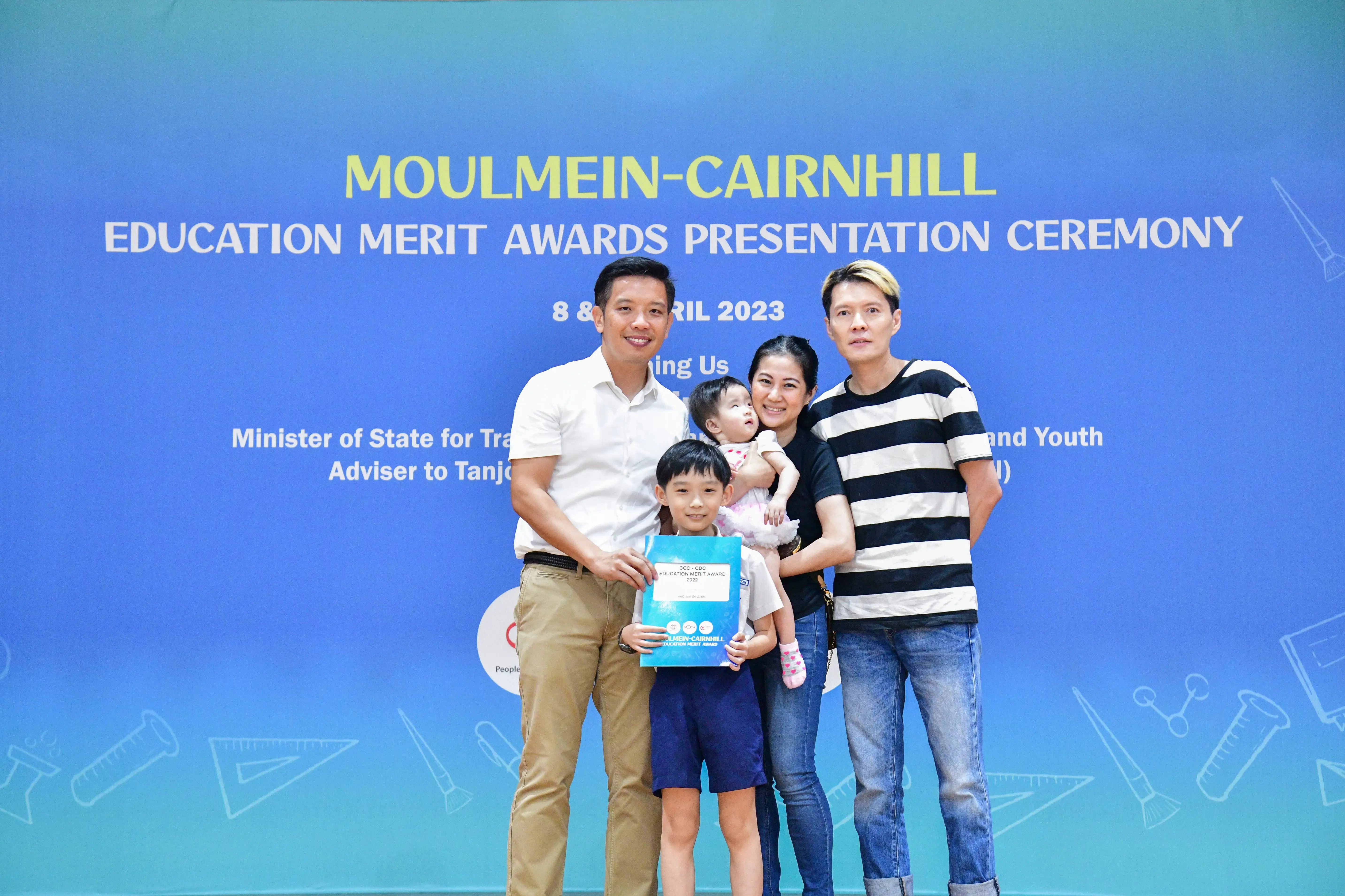 Family of four posing with an official at the Moulmein-Cairnhill Education Merit Awards Ceremony, April 2023.