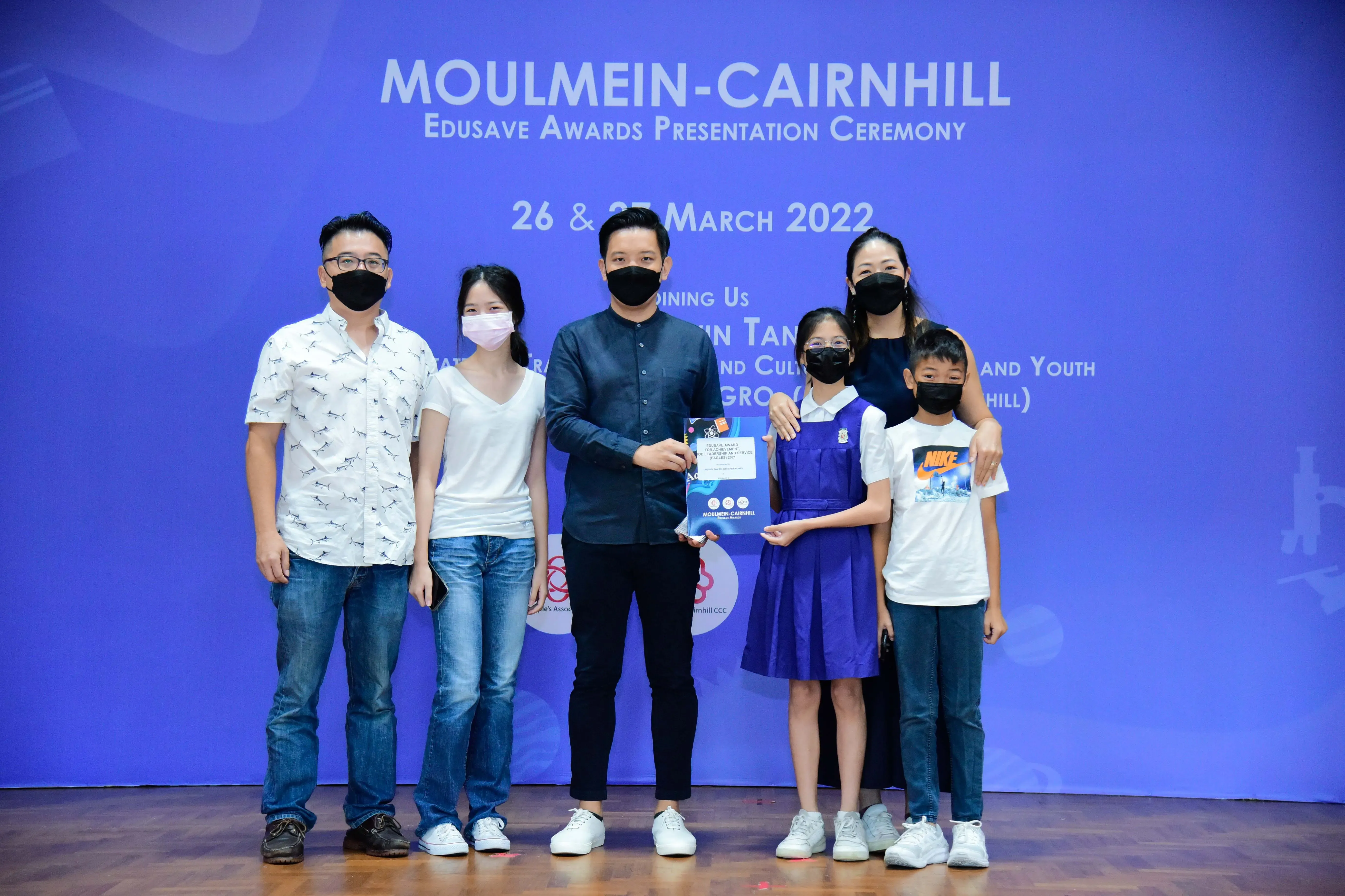Six masked people pose at the Moulmein-Cairnhill Edusave Awards Presentation Ceremony on 26 and 27 March 2022.