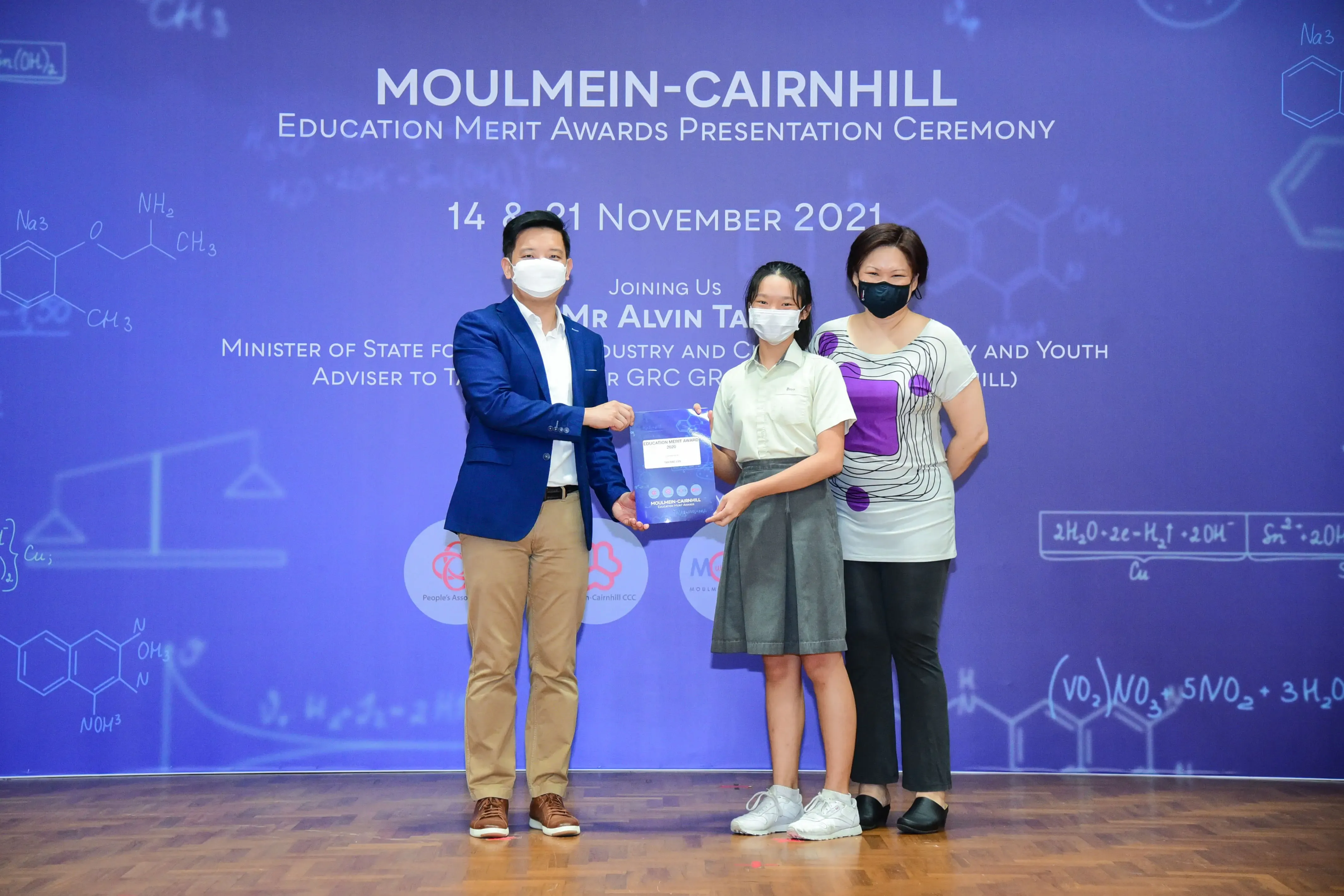 Three masked people pose at the Moulmein-Cairnhill Education Merit Awards Presentation Ceremony, November 2021.