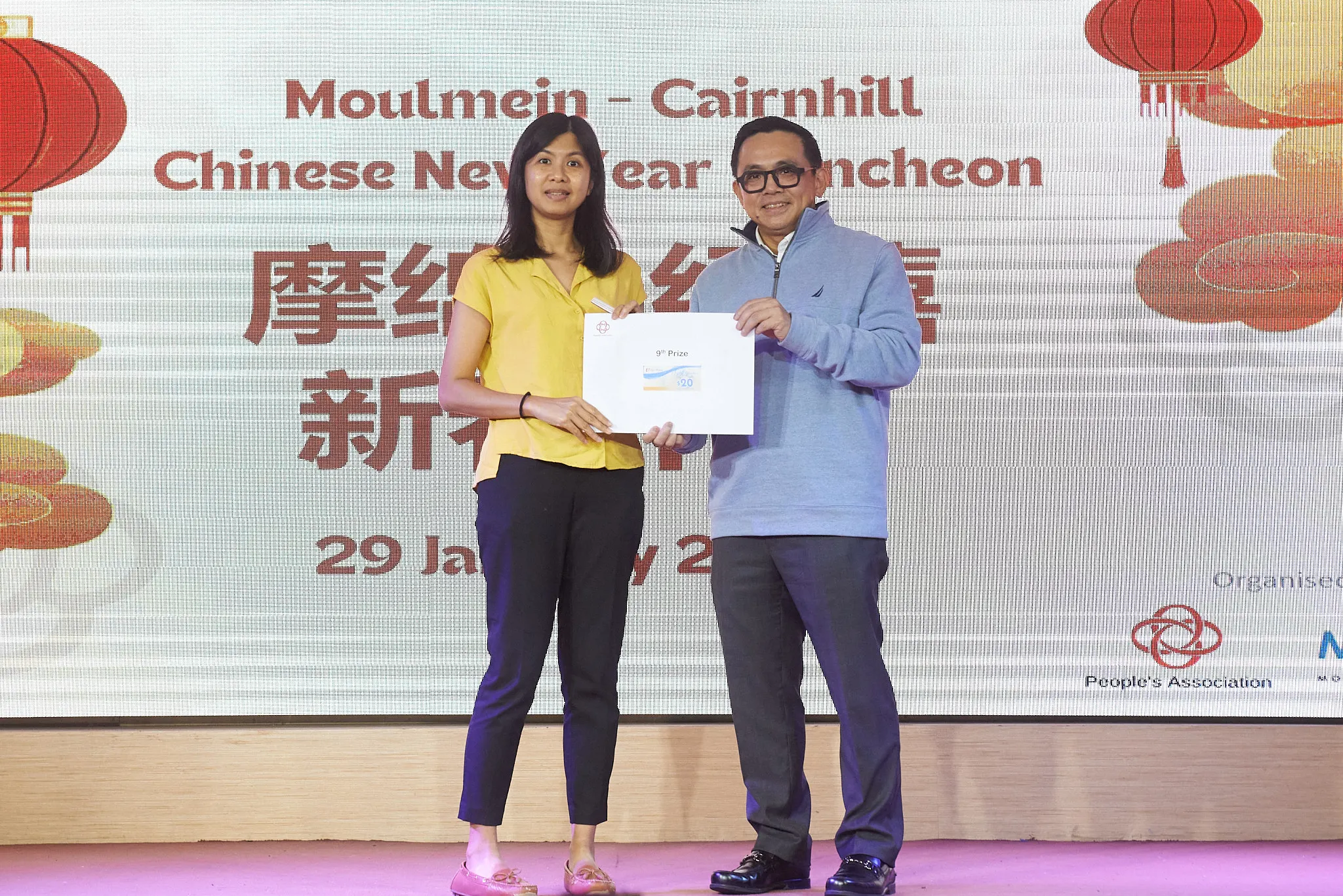 Two people hold a prize envelope at the Moulmein-Cairnhill Chinese New Year Luncheon on 29 January.