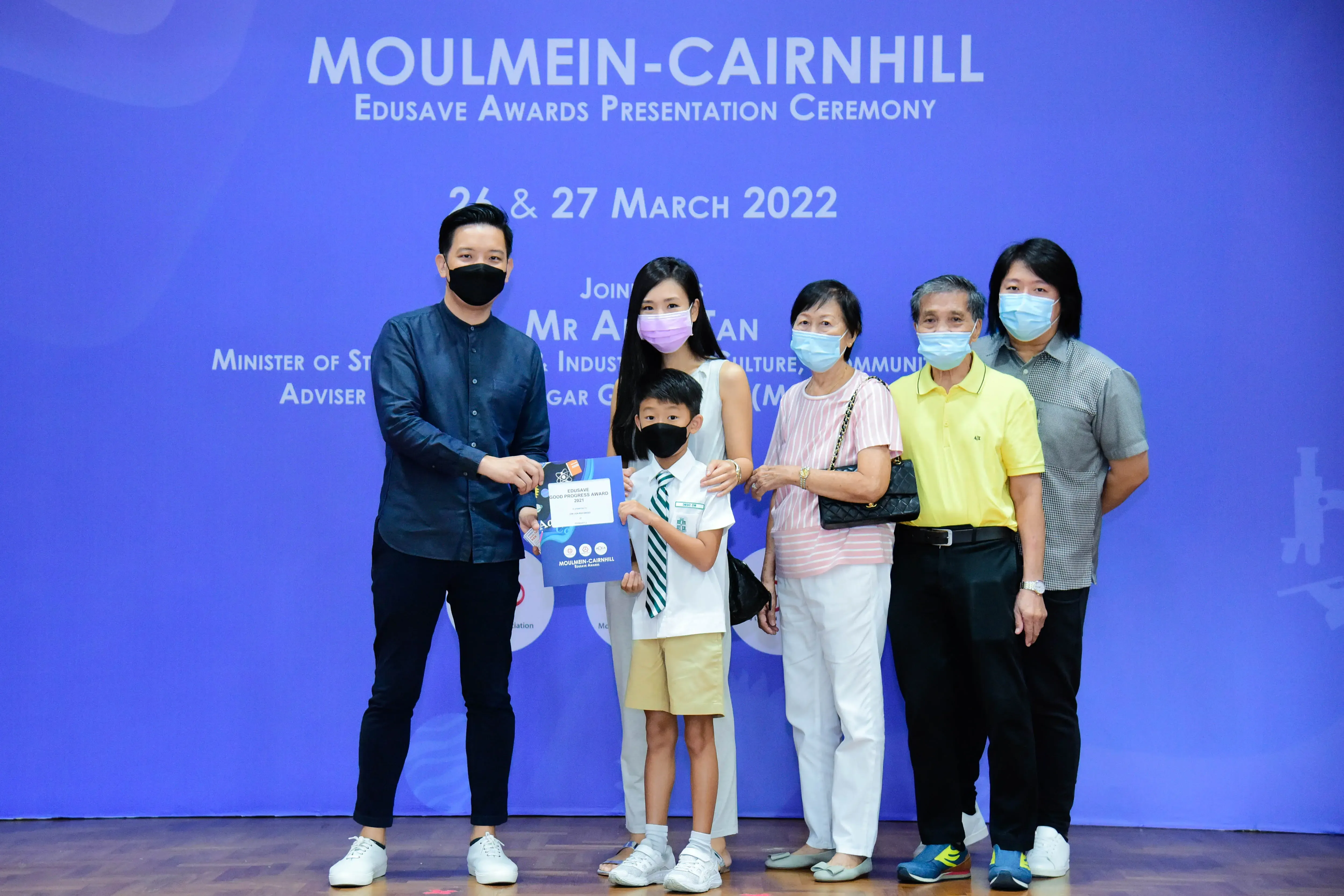 Six masked people pose at the Moulmein-Cairnhill Edusave Awards Presentation Ceremony on 26-27 March 2022.