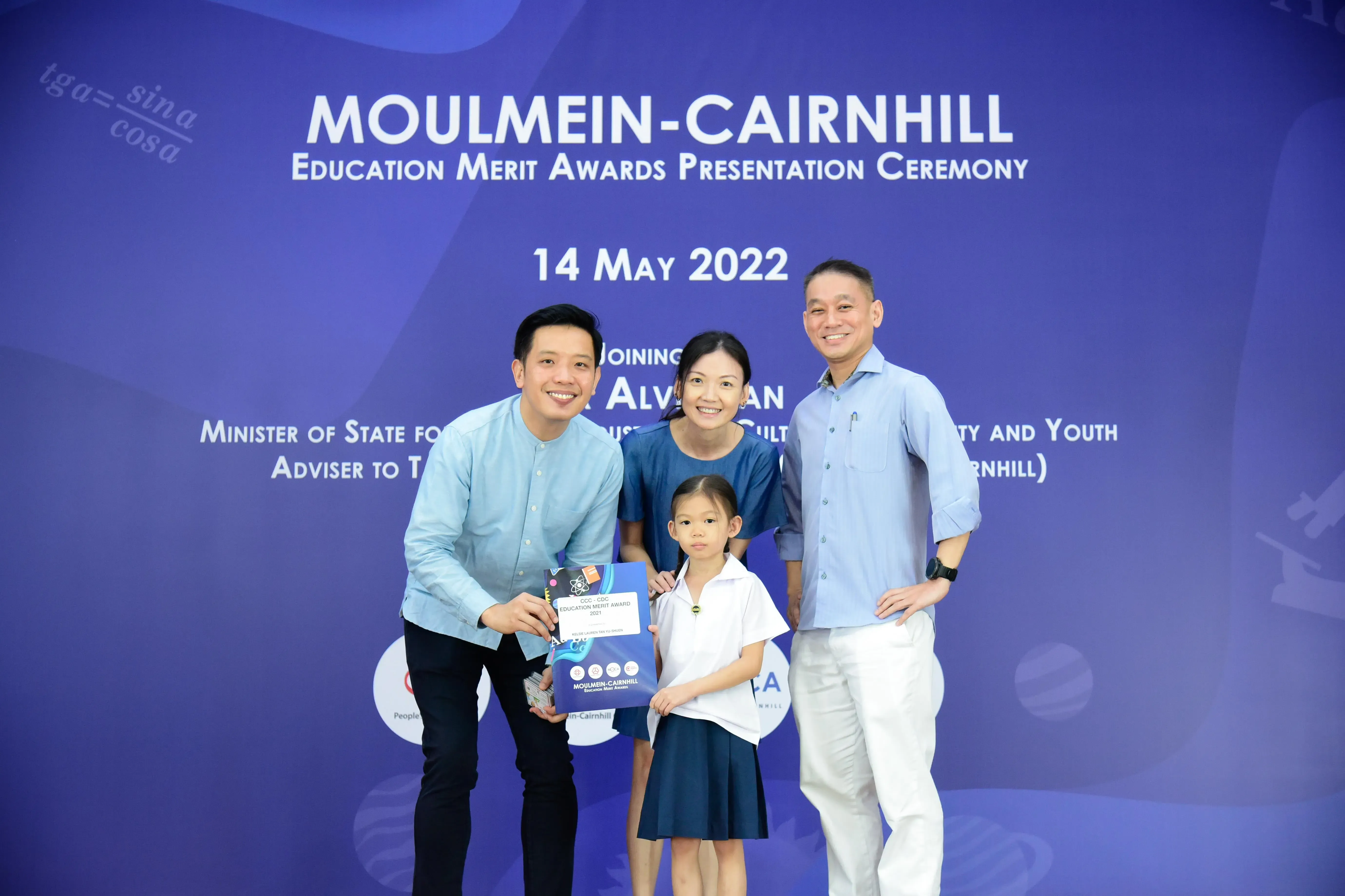 Three adults and a young girl pose at the Moulmein-Cairnhill Education Merit Awards Ceremony on 14 May 2022.