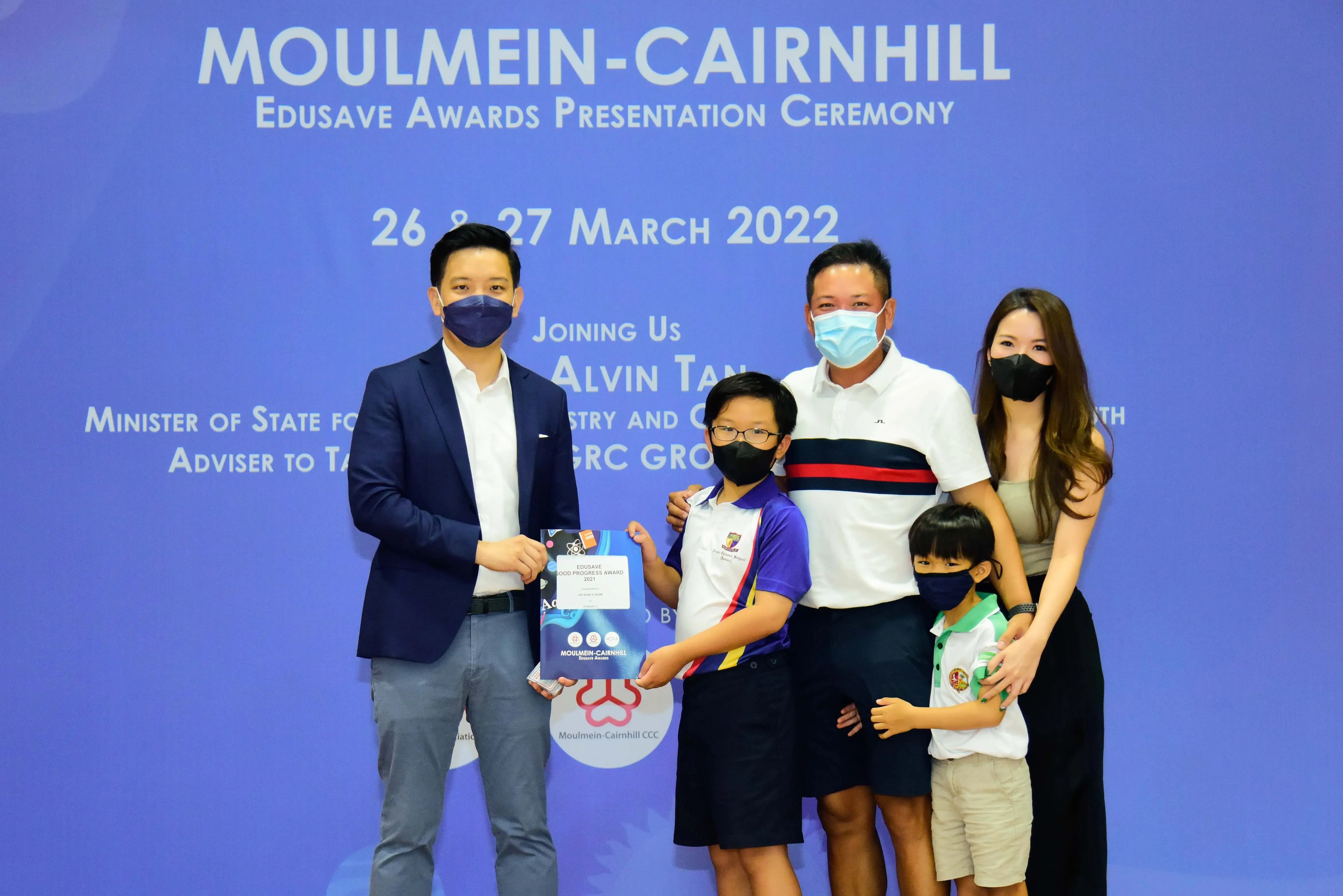 Five masked people pose at the Moulmein-Cairnhill Edusave Awards Presentation Ceremony on 26-27 March 2022.