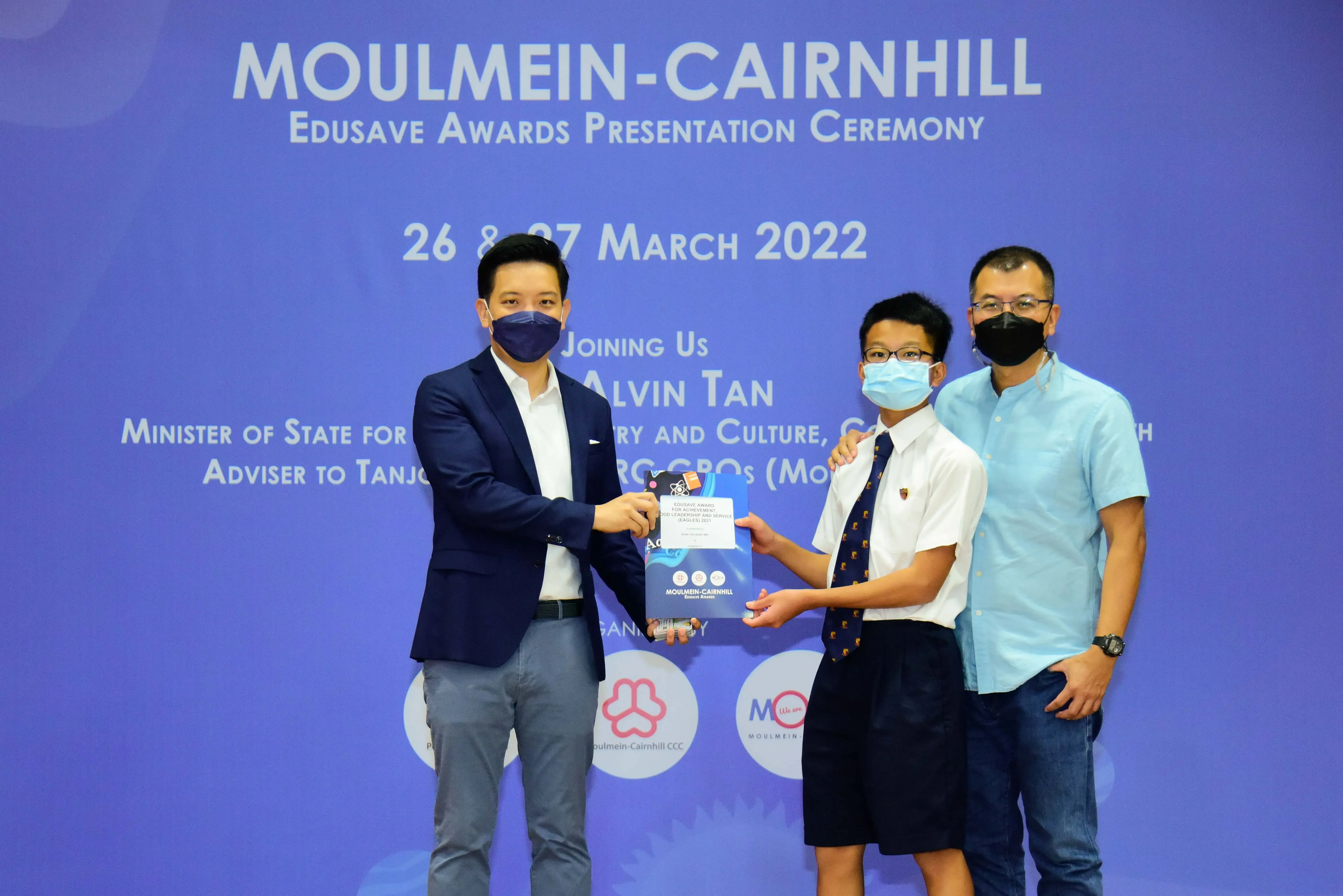 Three masked people pose at the Moulmein-Cairnhill Edusave Awards Presentation Ceremony on 26-27 March 2022.