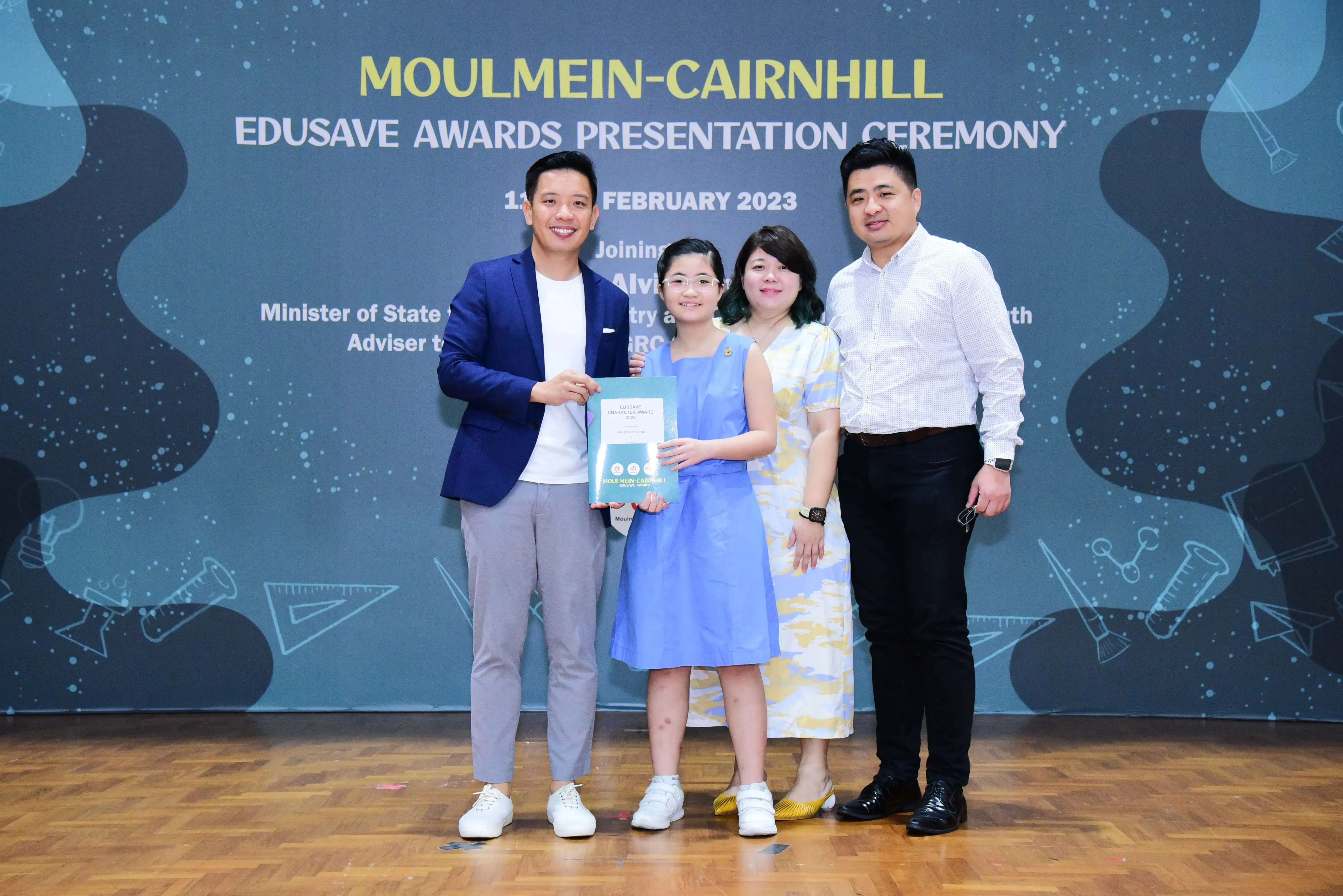 Four people pose together at the Moulmein-Cairnhill Edusave Awards Presentation Ceremony in February 2023.
