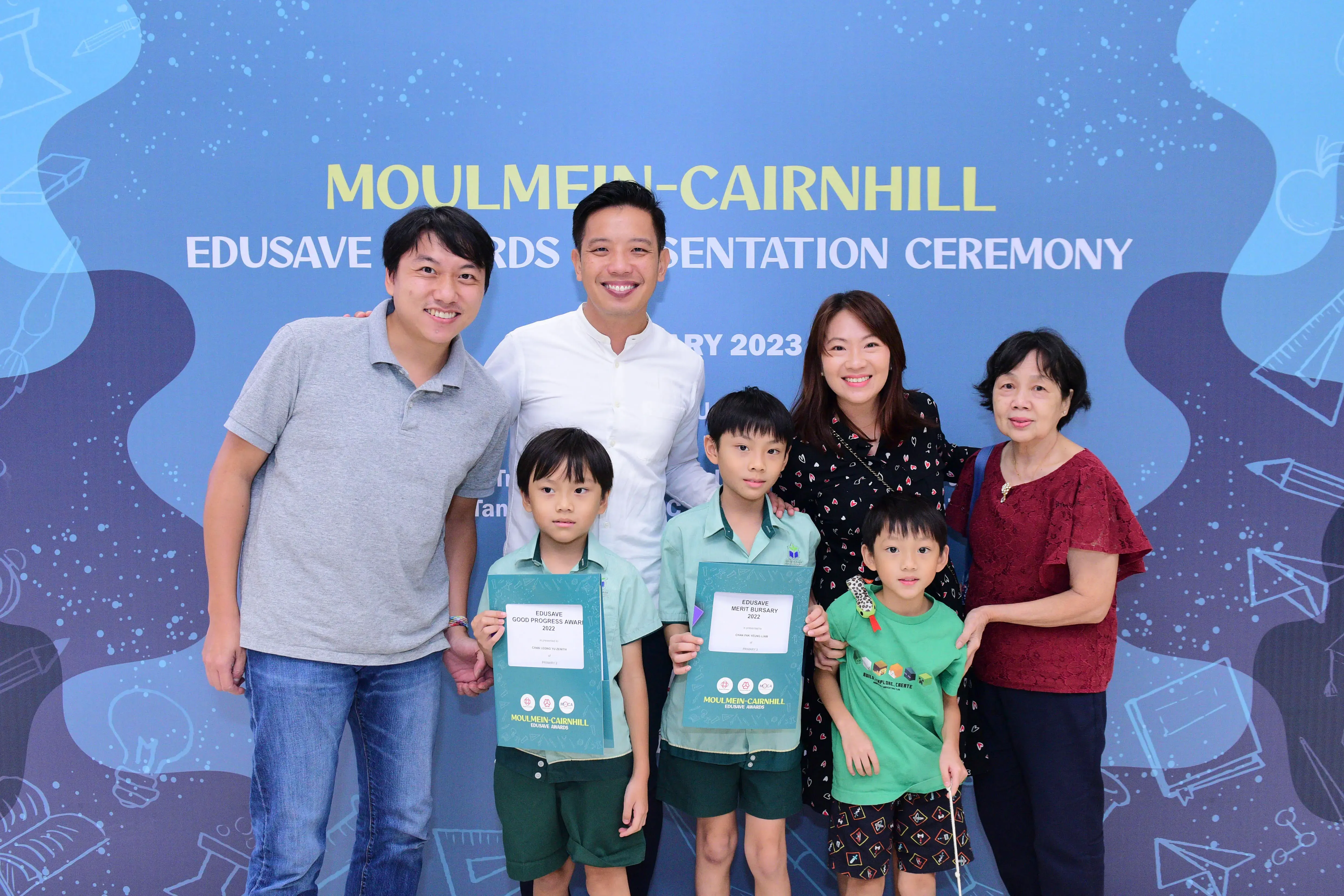 Four adults and three children pose at the Moulmein-Cairnhill Edusave Awards Presentation Ceremony 2023.