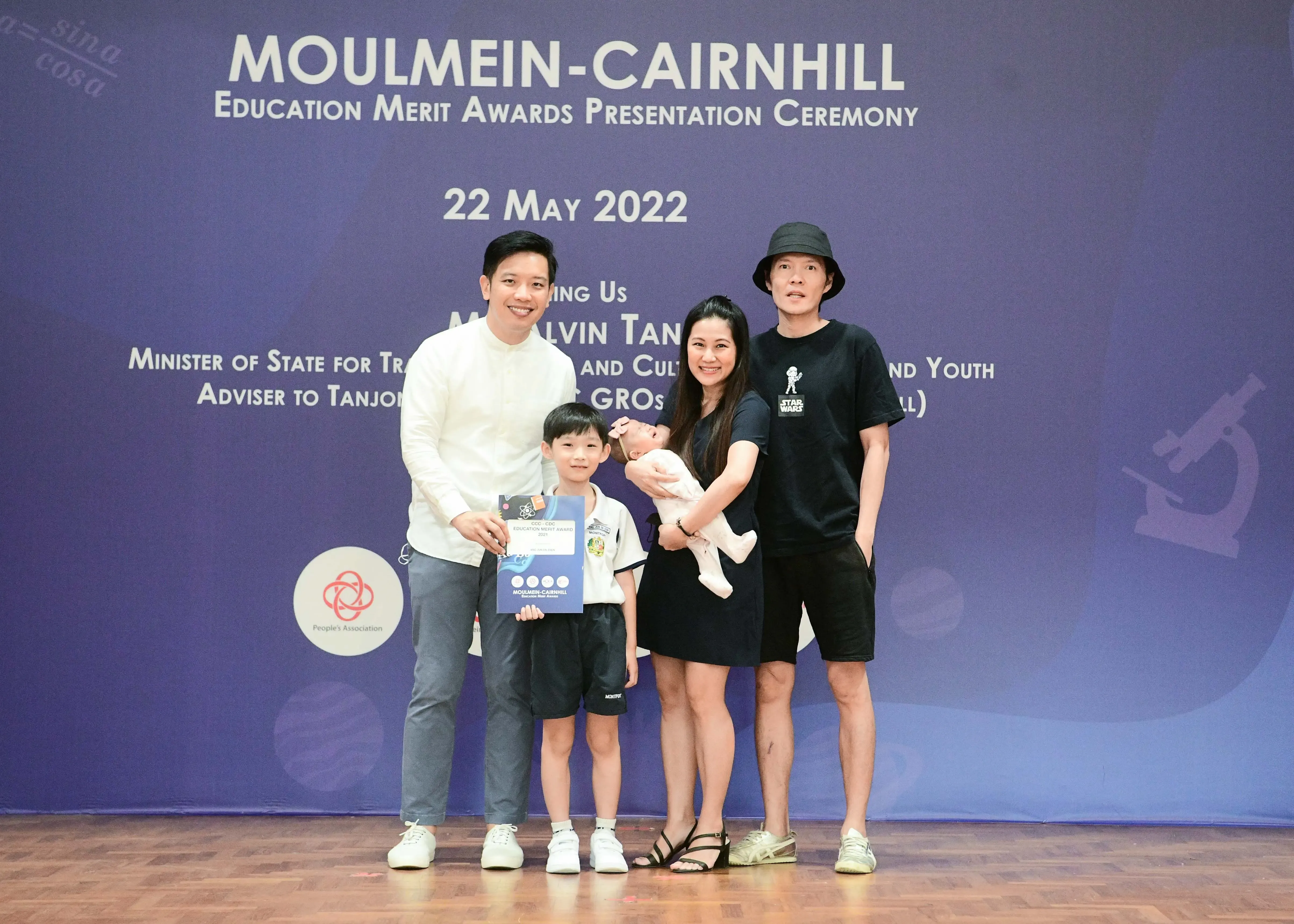 Family of four posing at Moulmein-Cairnhill Education Merit Awards Presentation Ceremony on 22 May 2022.