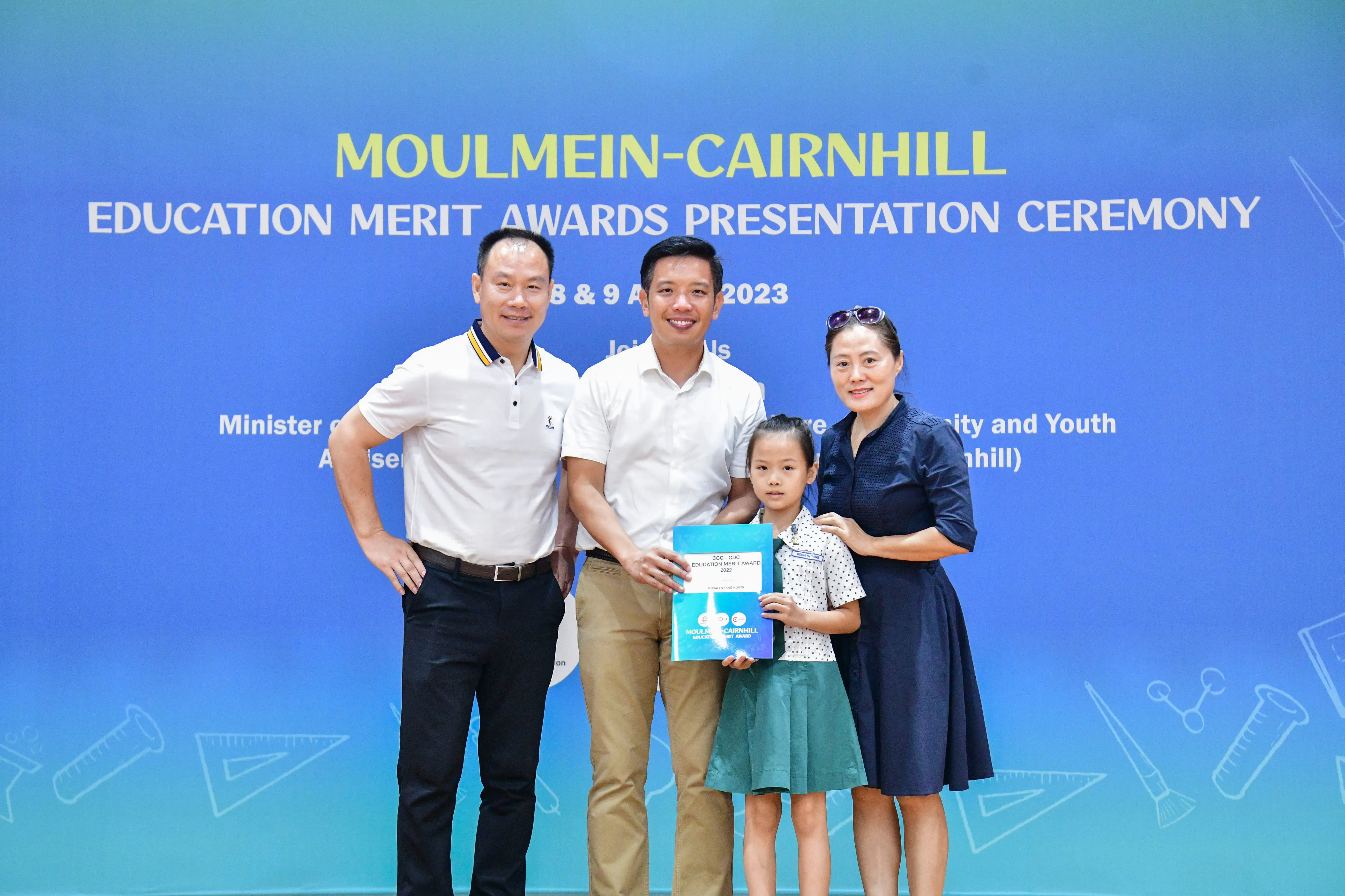 Three adults and a young girl pose at the Moulmein-Cairnhill Education Merit Awards Ceremony 2023.