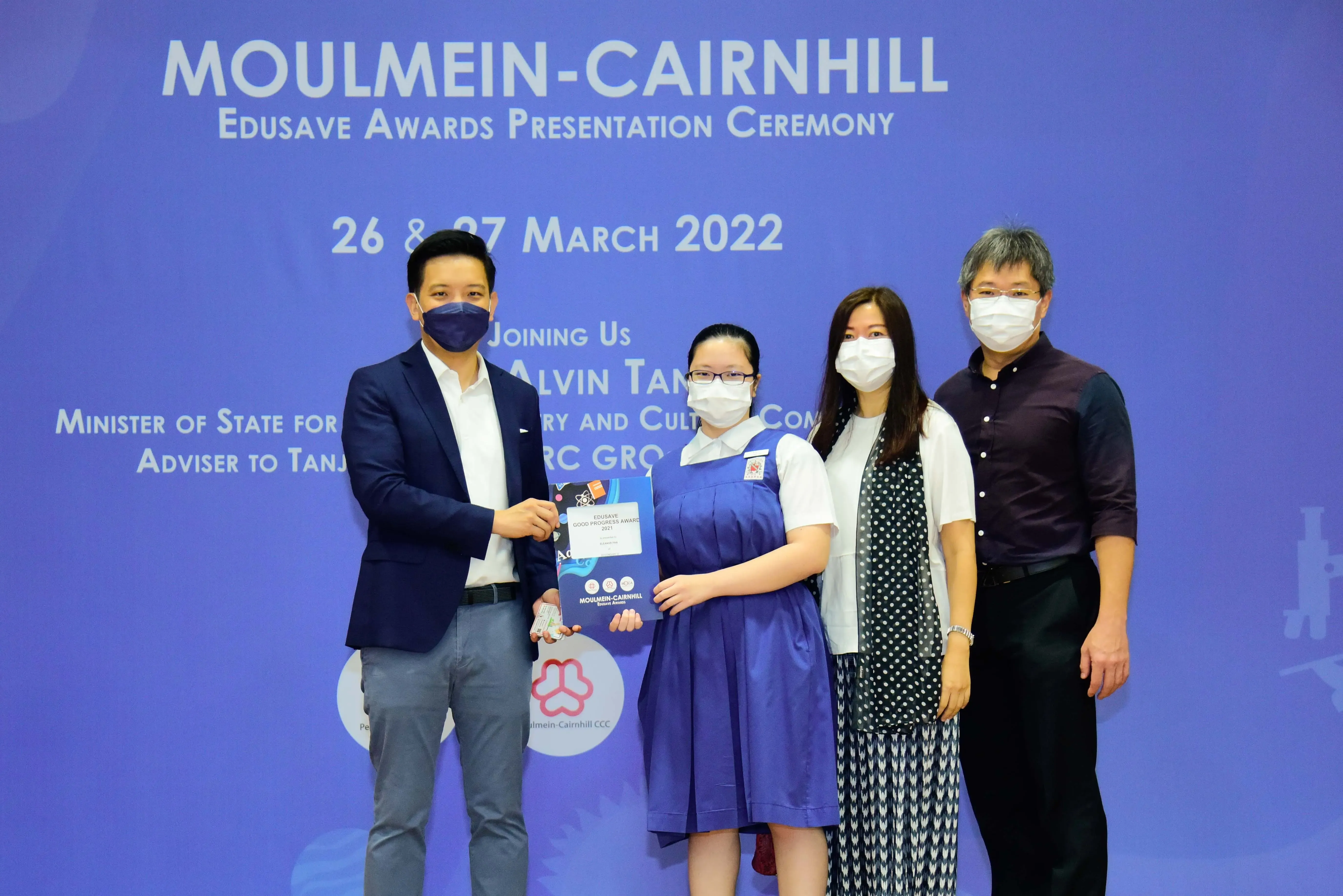 Four masked people pose at the Moulmein-Cairnhill Edusave Awards Presentation Ceremony on 26-27 March 2022.