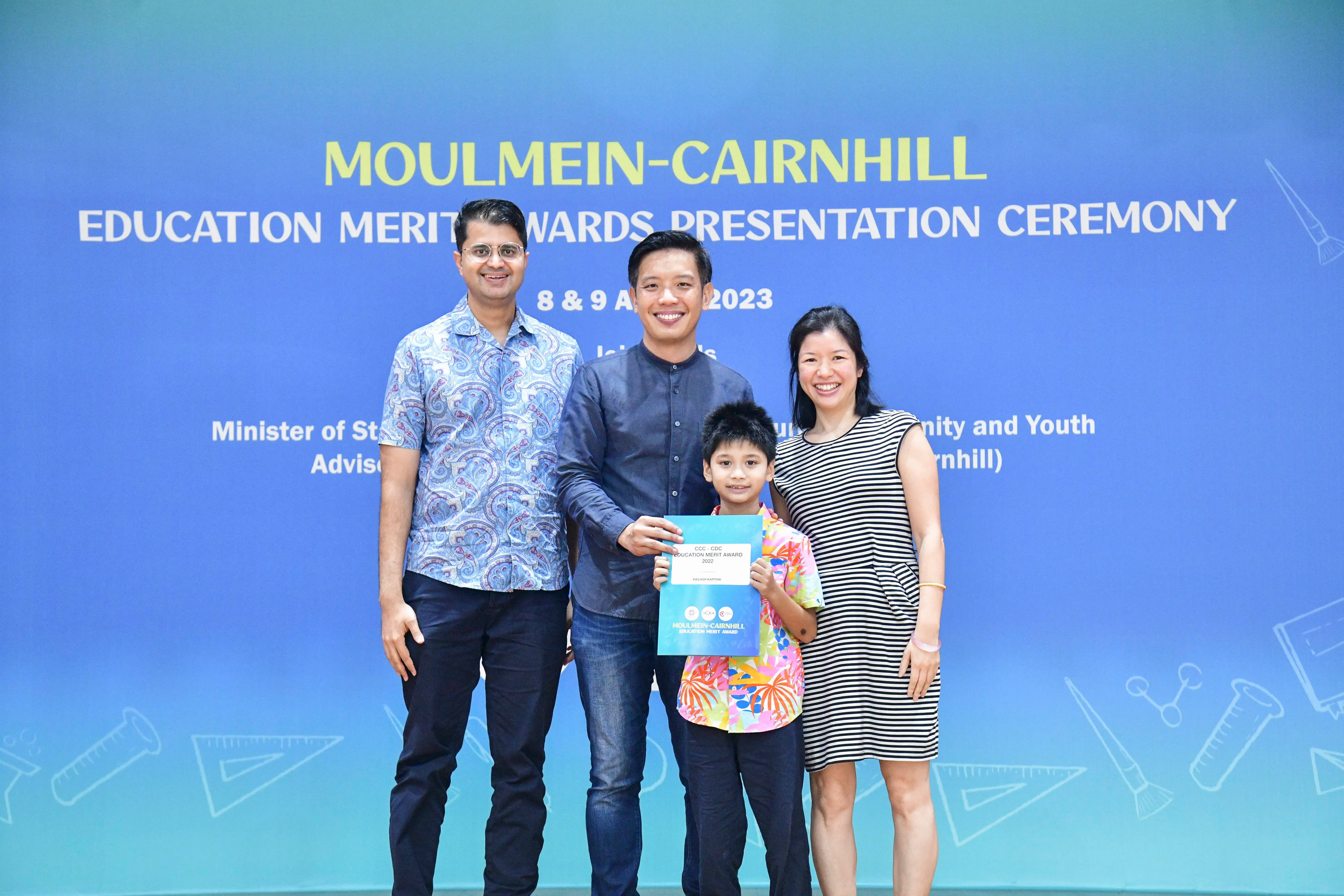 Three adults and a boy holding a certificate pose at the Moulmein-Cairnhill Education Merit Awards ceremony in 2023.