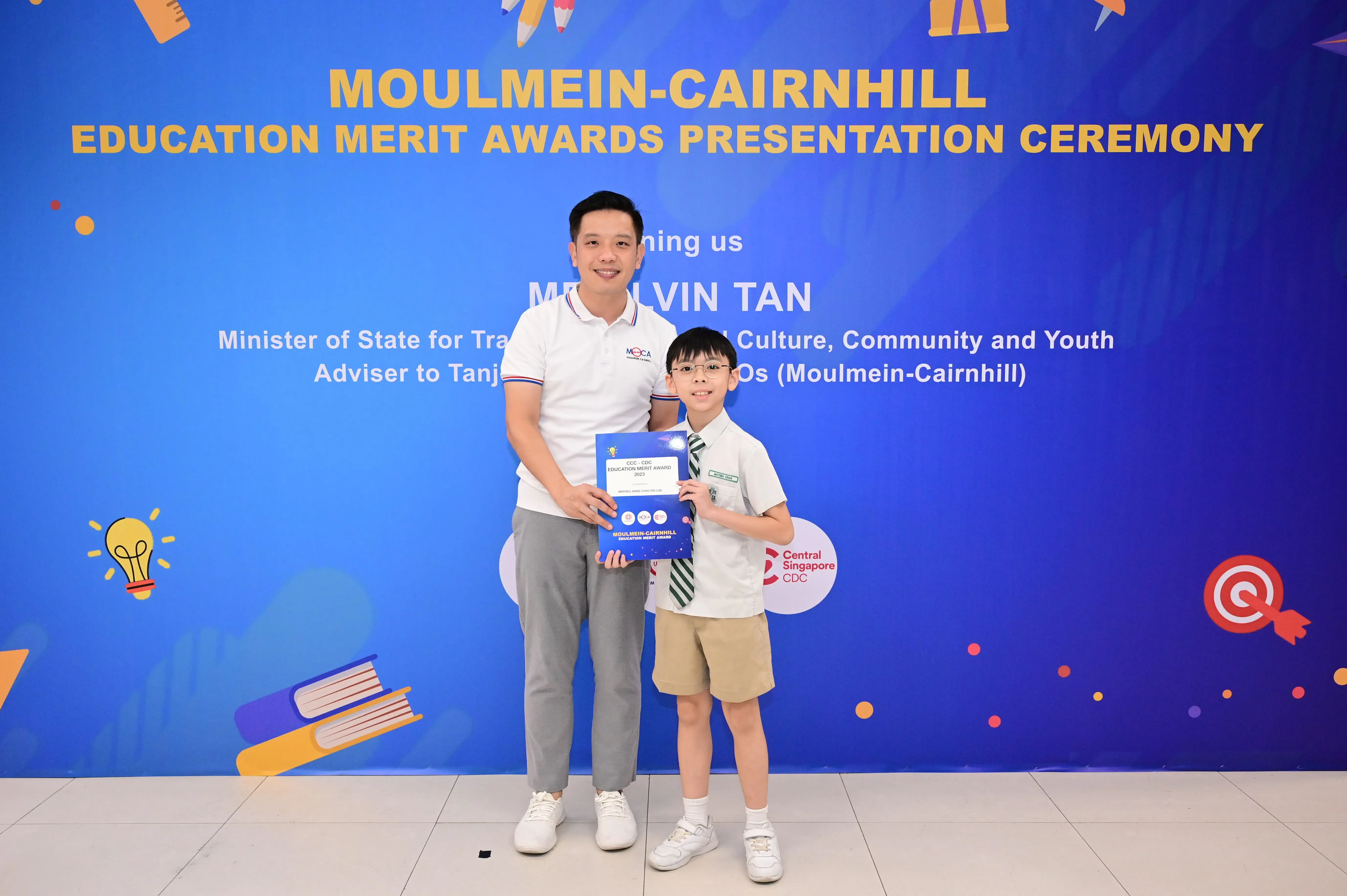 Man and young boy holding a certificate at Moulmein-Cairnhill Education Merit Awards Presentation Ceremony.