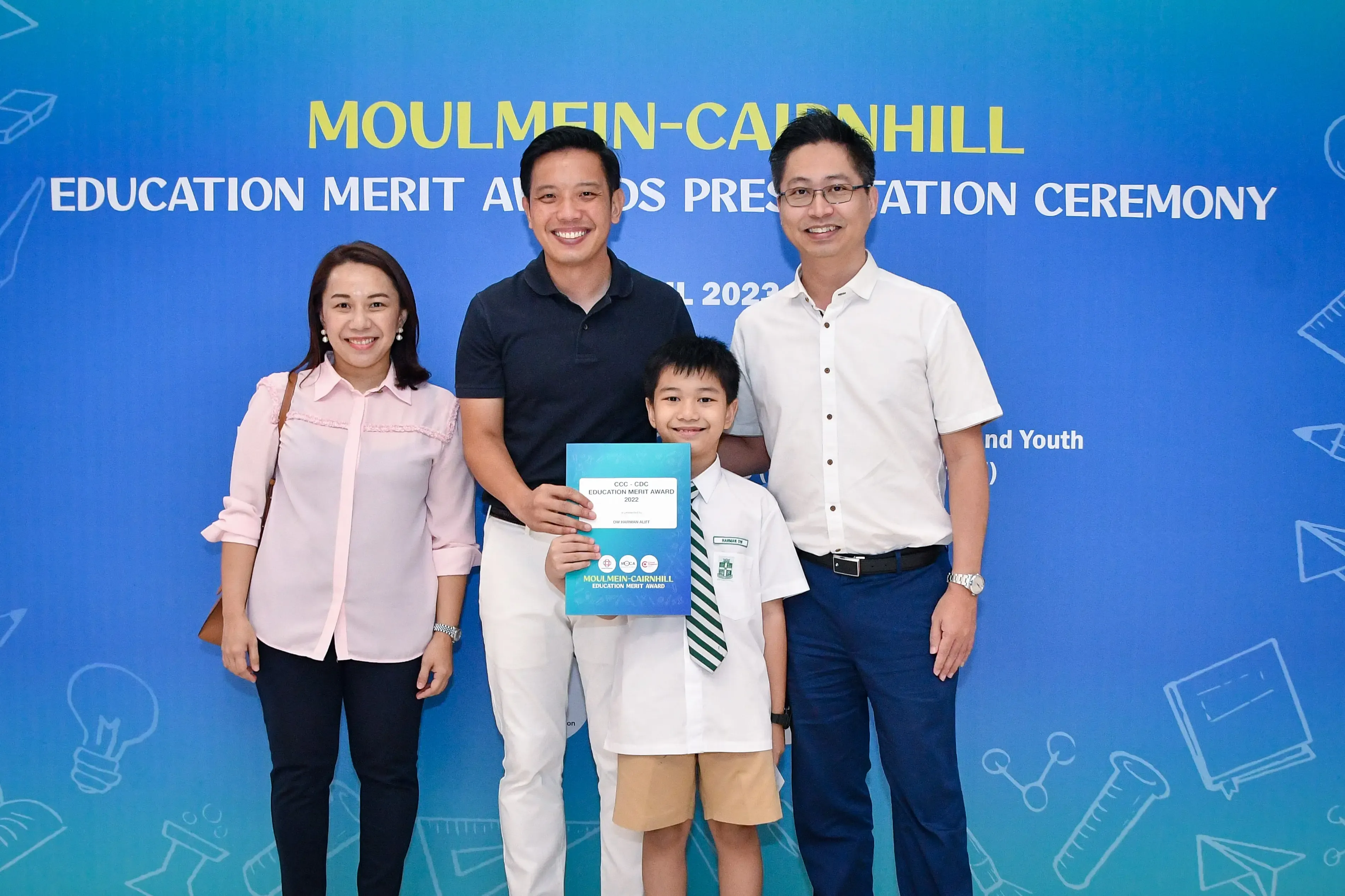 Three adults and a boy holding a certificate pose at the Moulmein-Cairnhill Education Merit Awards 2023.