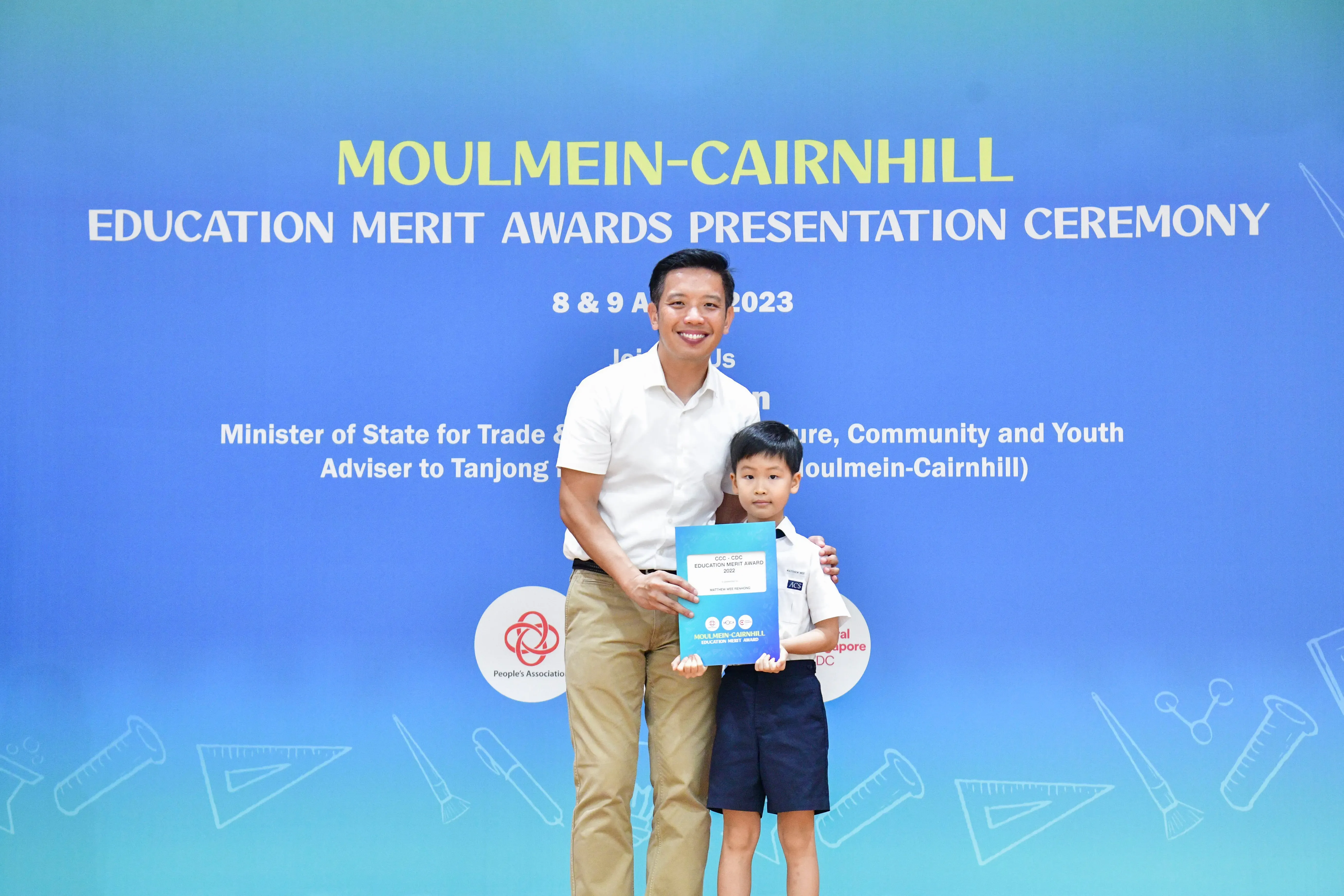 A man and a young boy pose together holding an award certificate at the Moulmein-Cairnhill Education Merit Awards 2023.