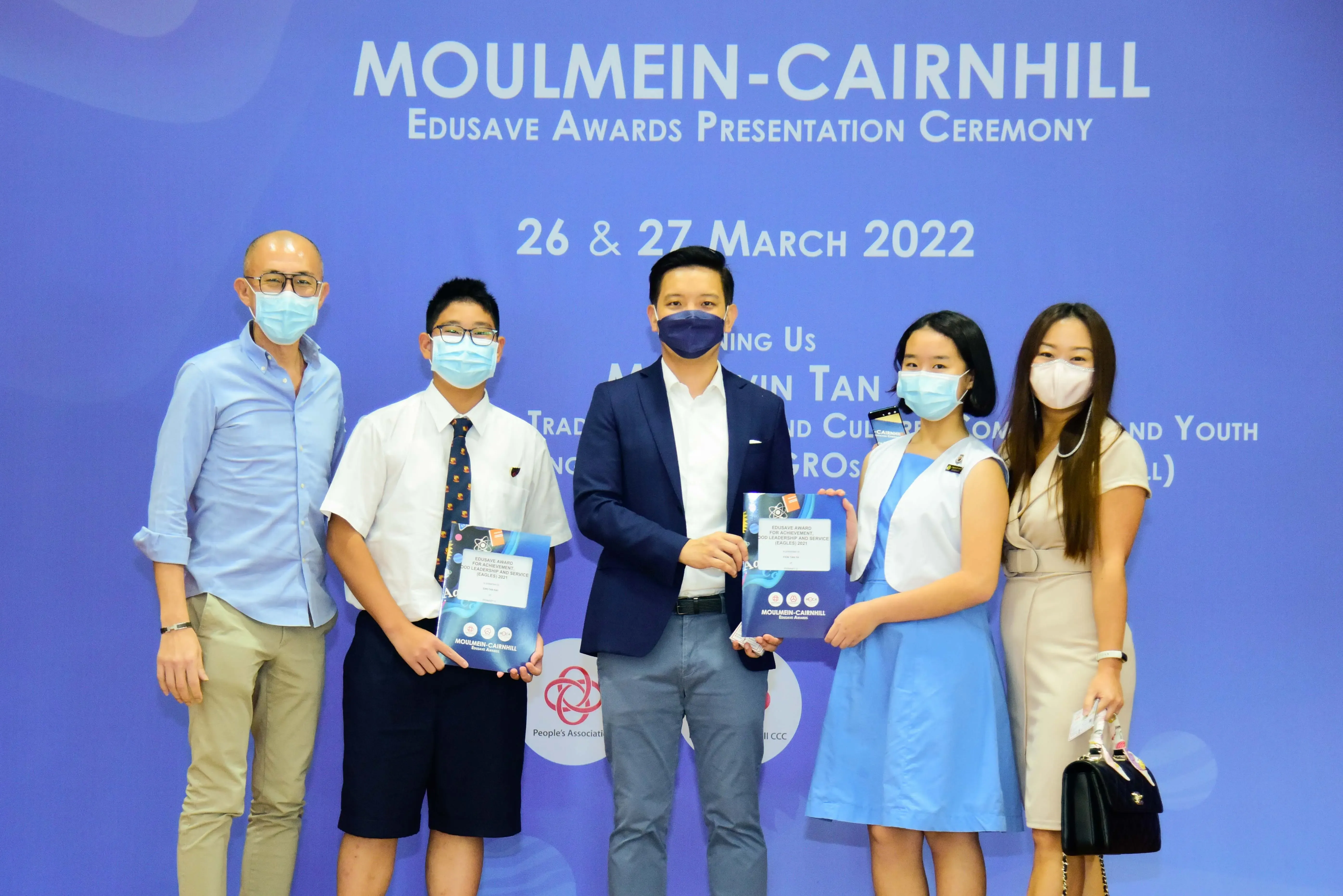 Five masked people pose at the Moulmein-Cairnhill Edusave Awards Presentation Ceremony on 26-27 March 2022.