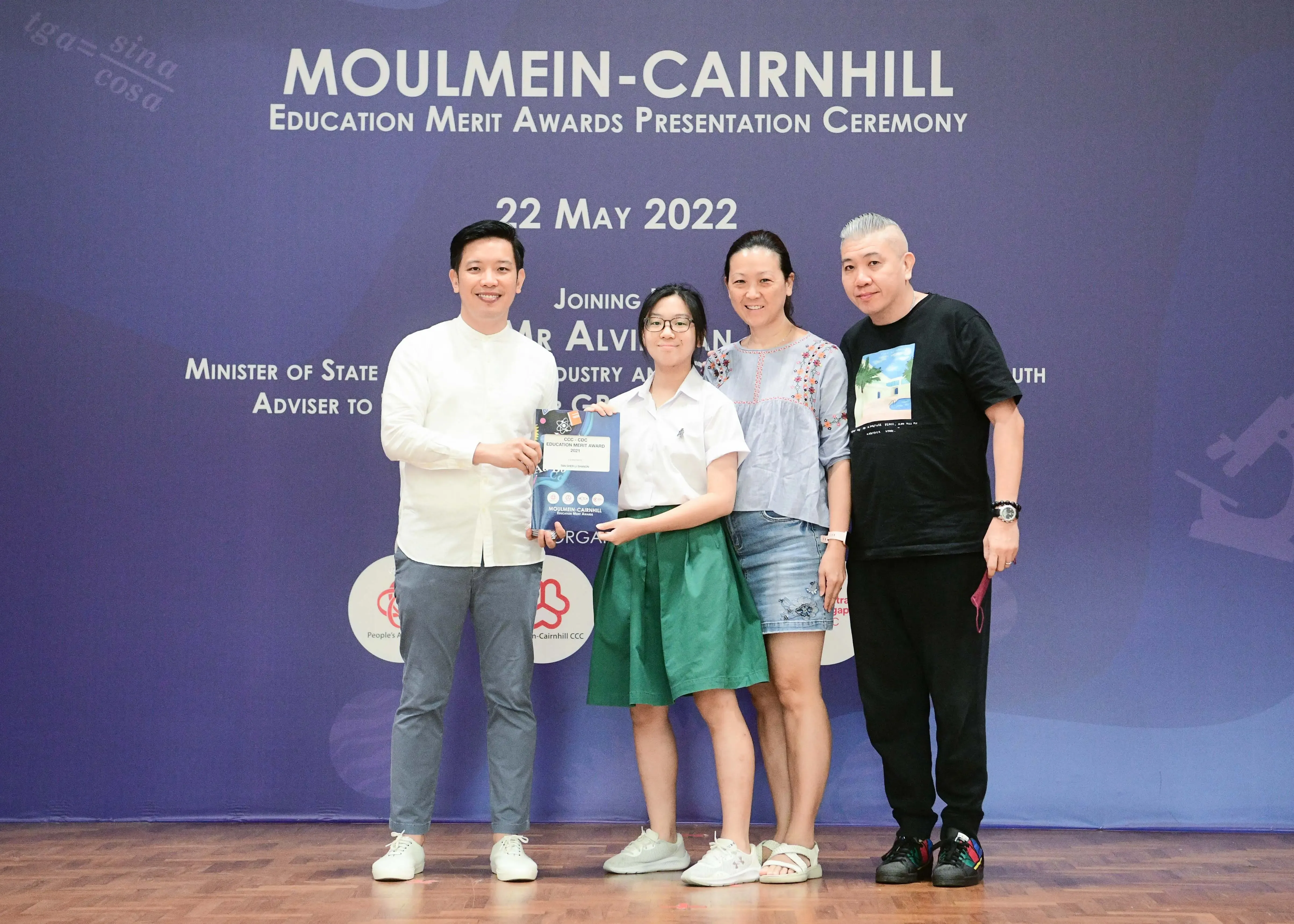 Four people pose on stage at the Moulmein-Cairnhill Education Merit Awards Ceremony on 22 May 2022.