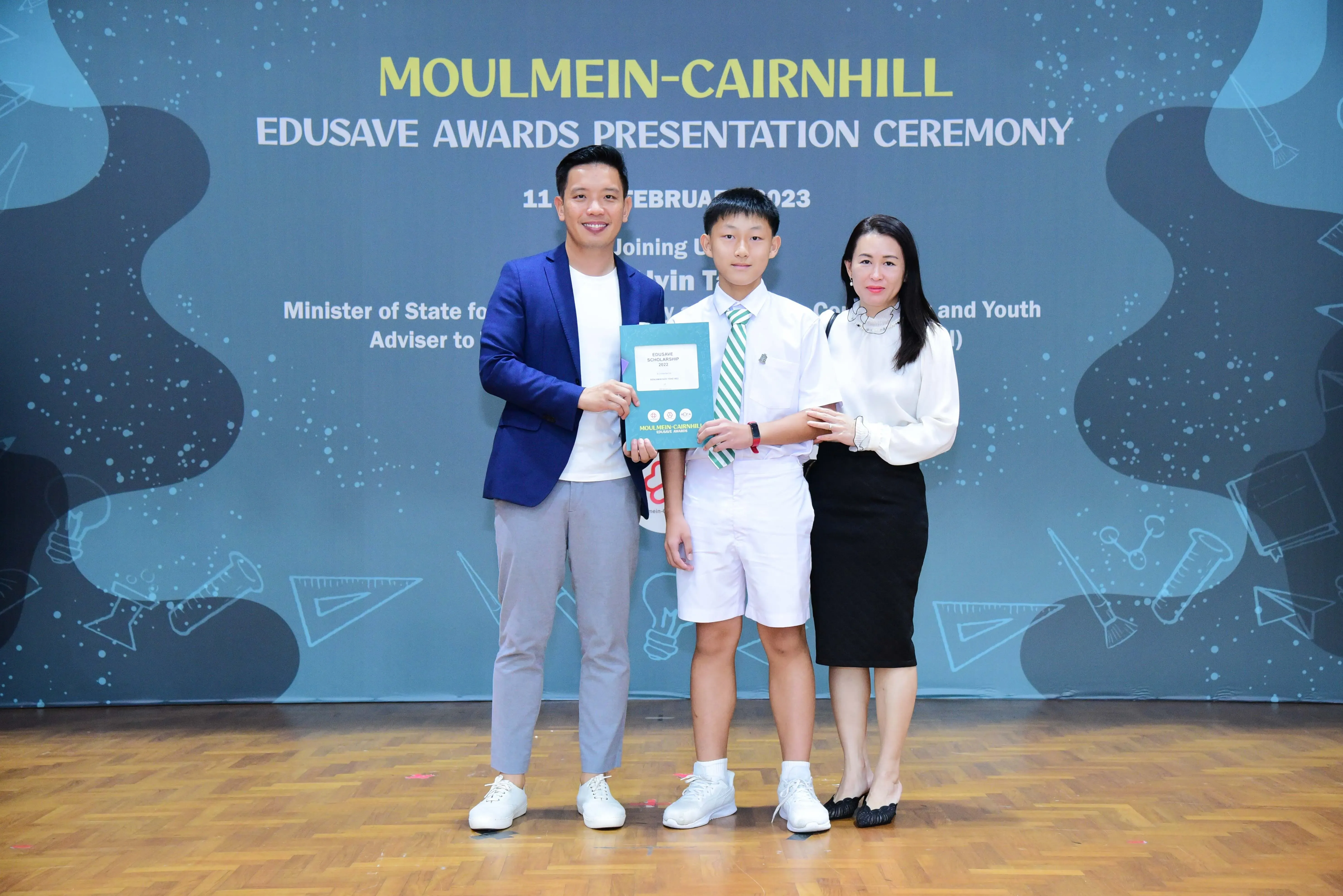 Three people pose with an award certificate at the Moulmein-Cairnhill Edusave Awards Presentation Ceremony 2023.