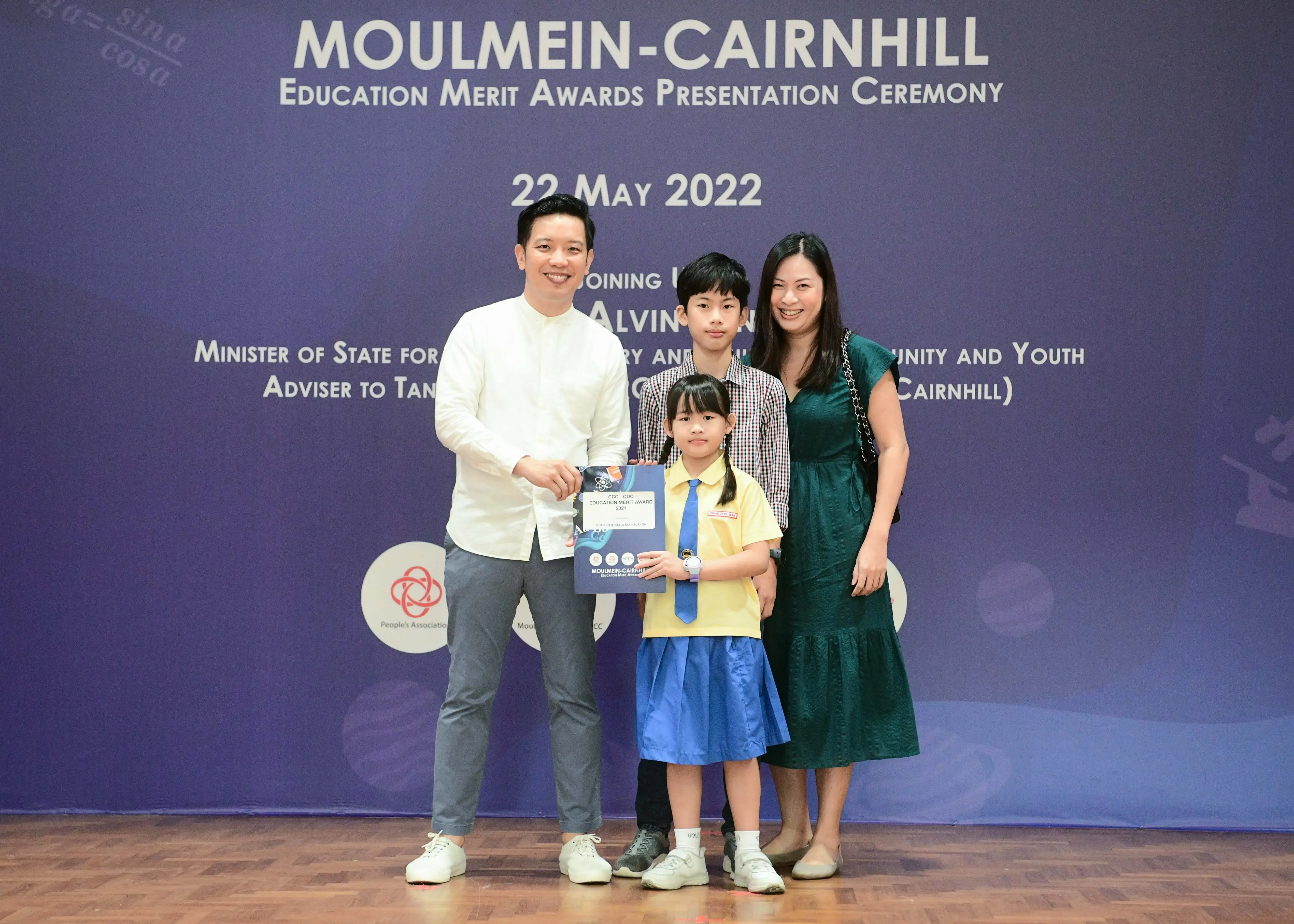 Four people pose with an award certificate at the Moulmein-Cairnhill Education Merit Awards ceremony on 22 May 2022.