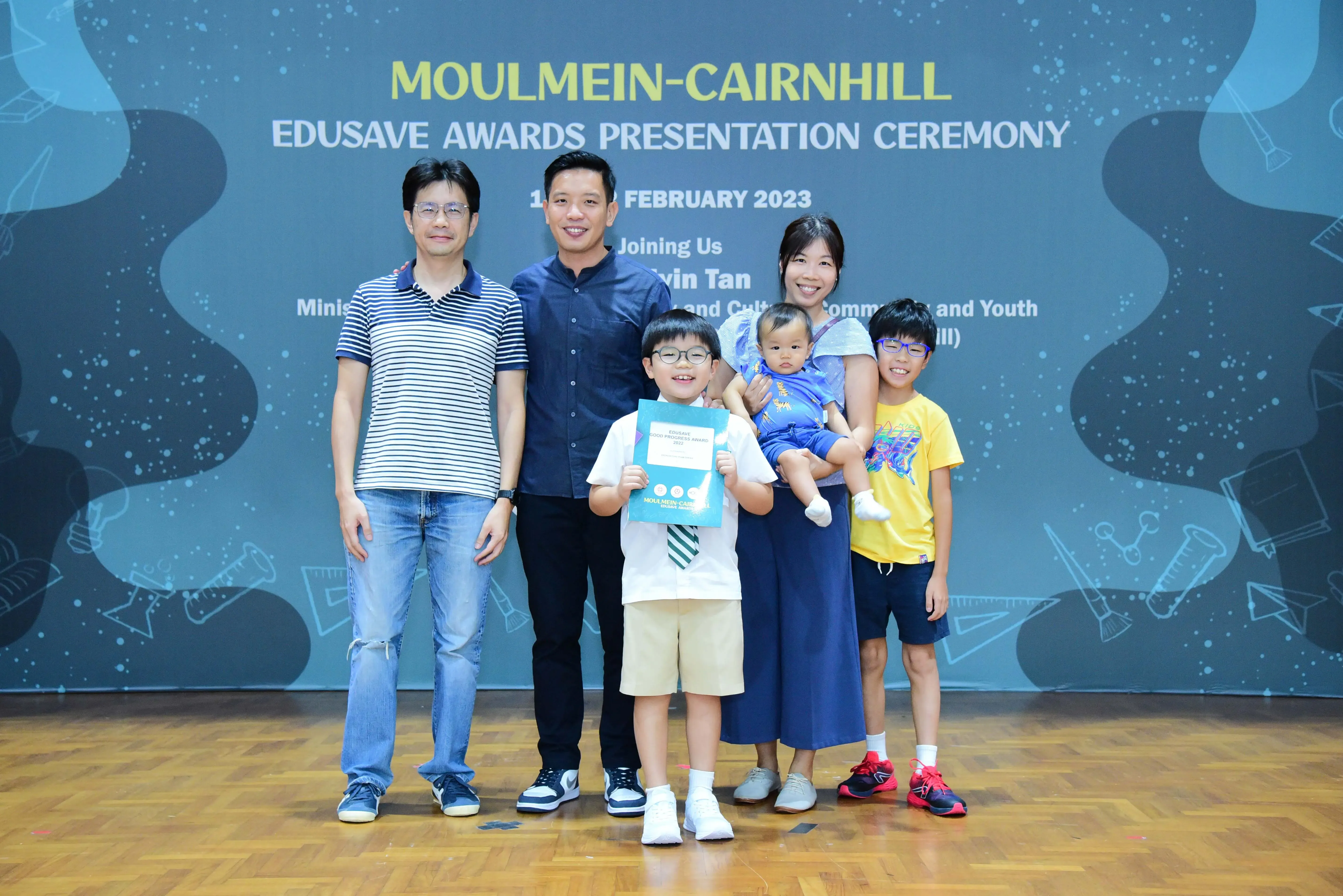 Family of five posing at the Moulmein-Cairnhill Edusave Awards Presentation Ceremony in February 2023.