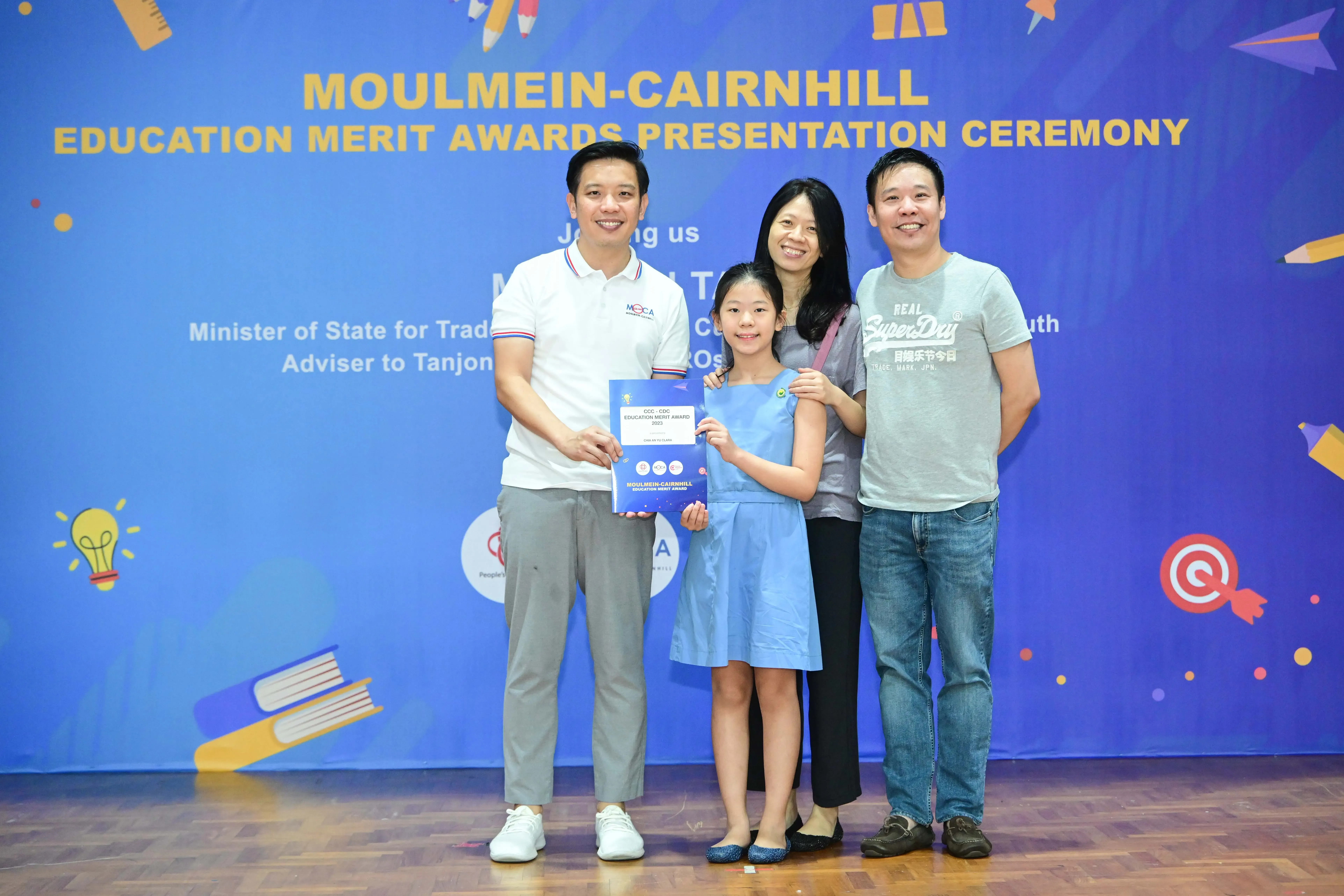 Four people pose with an award certificate at the Moulmein-Cairnhill Education Merit Awards Presentation Ceremony.