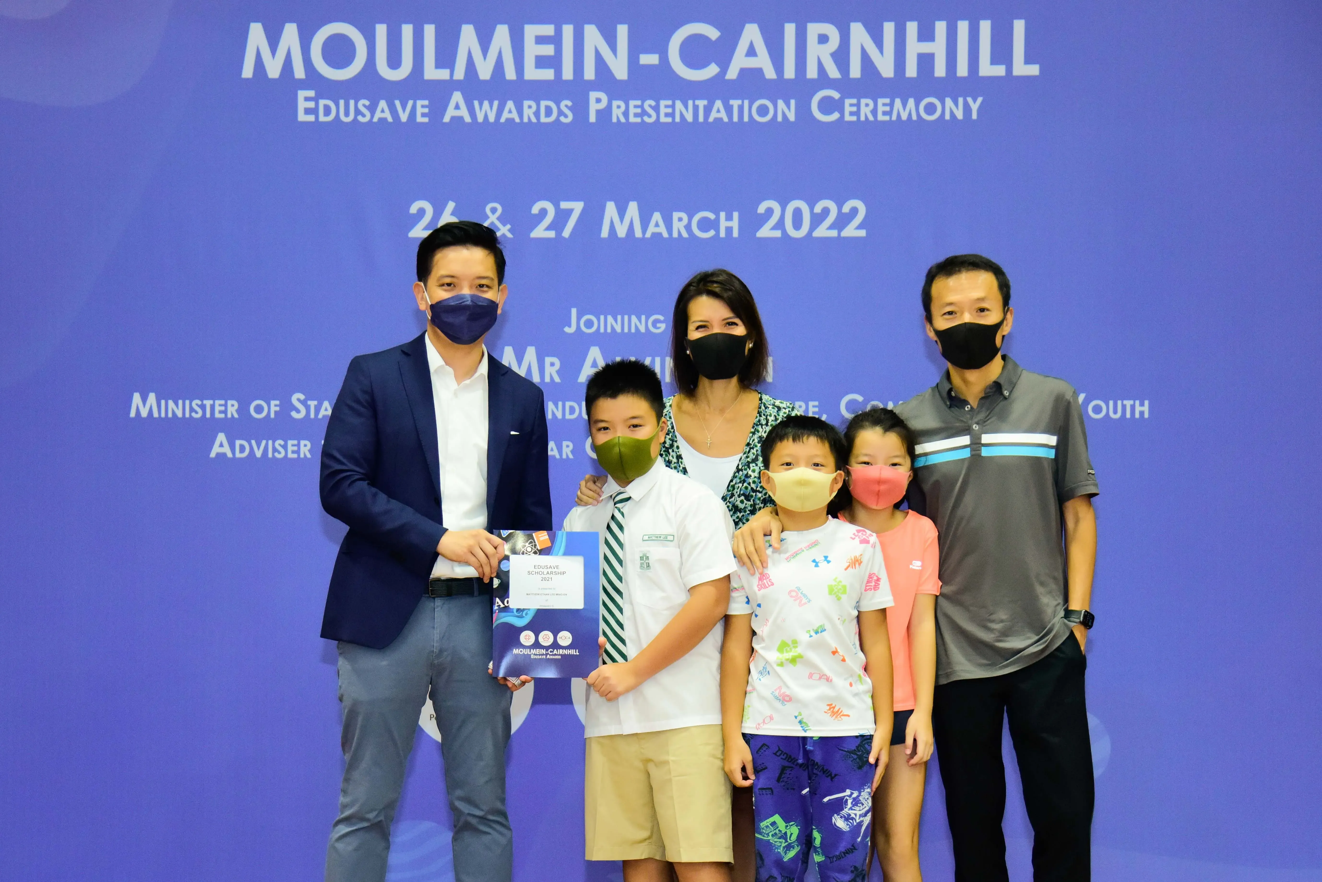 Five masked people pose at the Moulmein-Cairnhill Edusave Awards Presentation Ceremony on 26-27 March 2022.