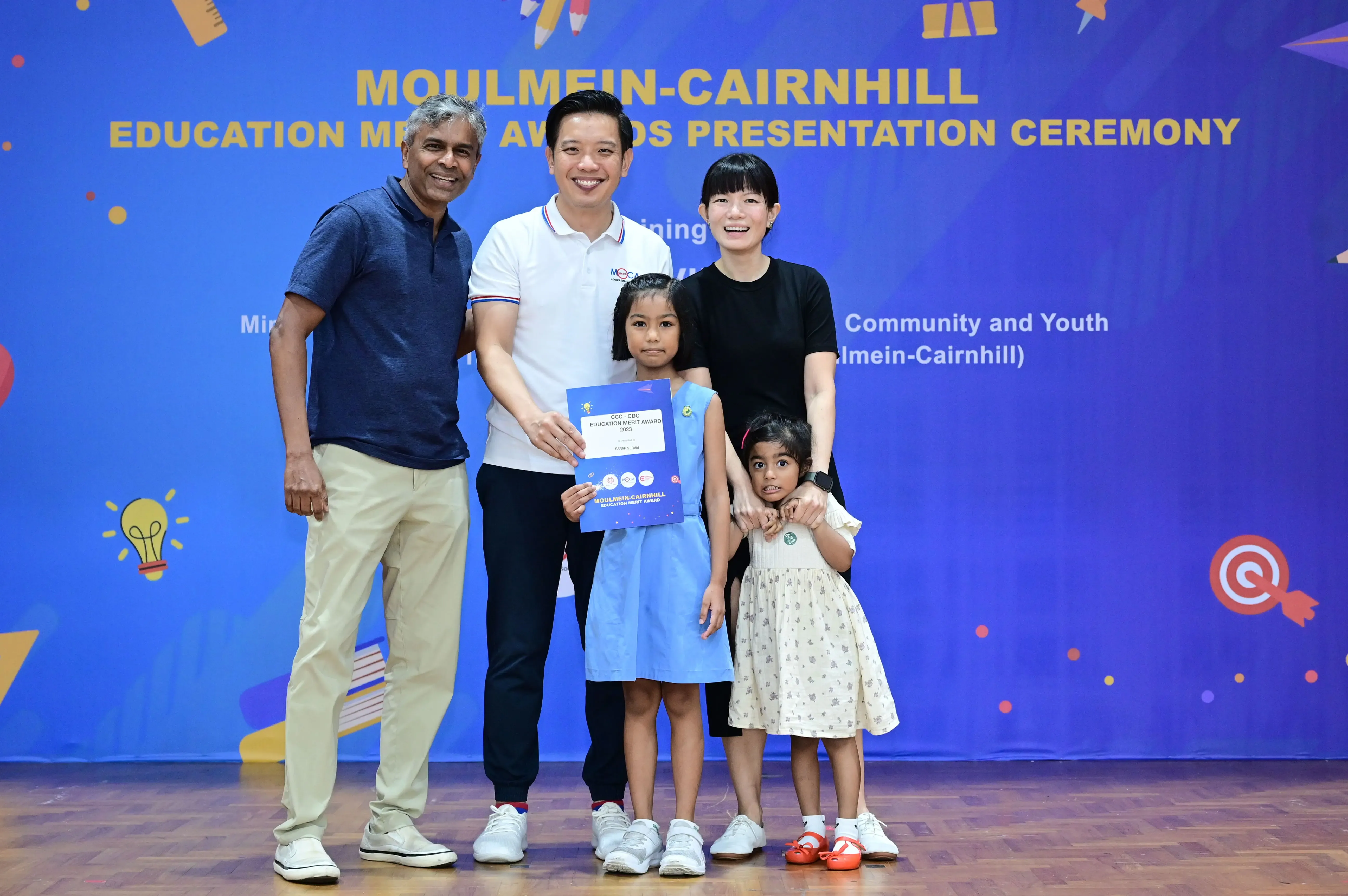Five people pose with a certificate at the Moulmein-Cairnhill Education Merit Awards Presentation Ceremony.