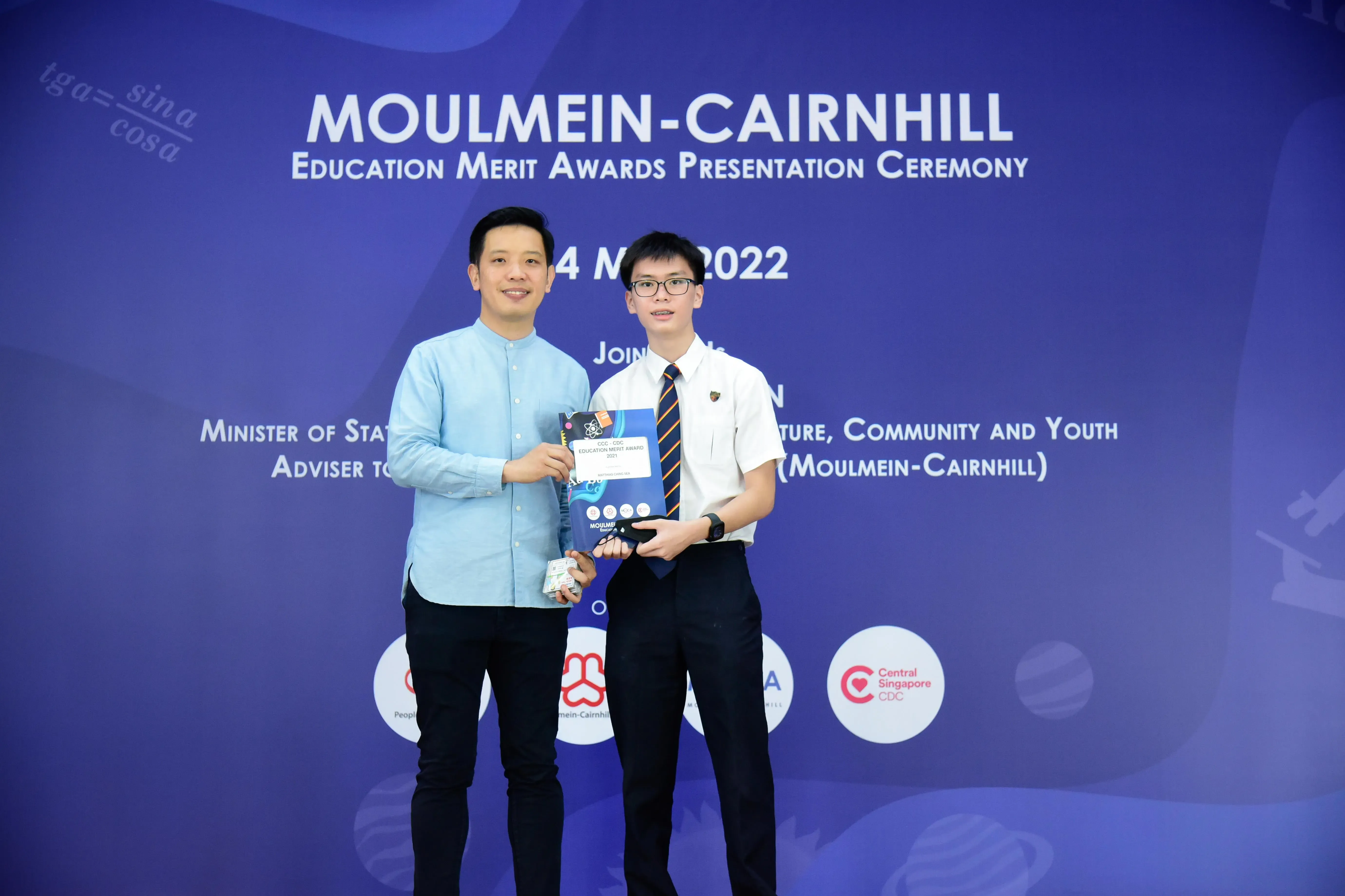 Two men pose holding an award at the Moulmein-Cairnhill Education Merit Awards Presentation Ceremony, May 2022.