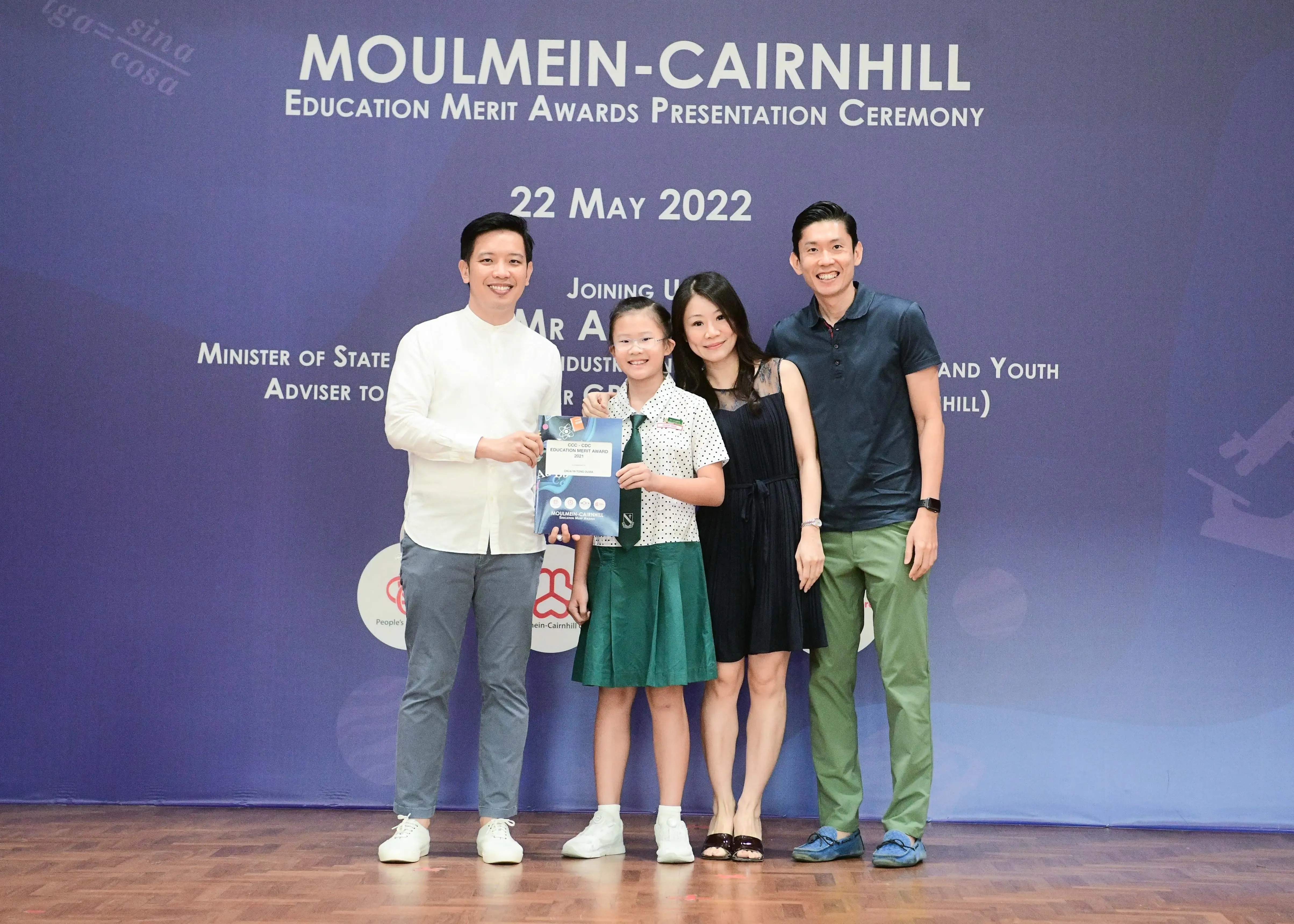 Three adults and a young girl in school uniform pose at the Moulmein-Cairnhill Education Merit Awards on 22 May 2022.