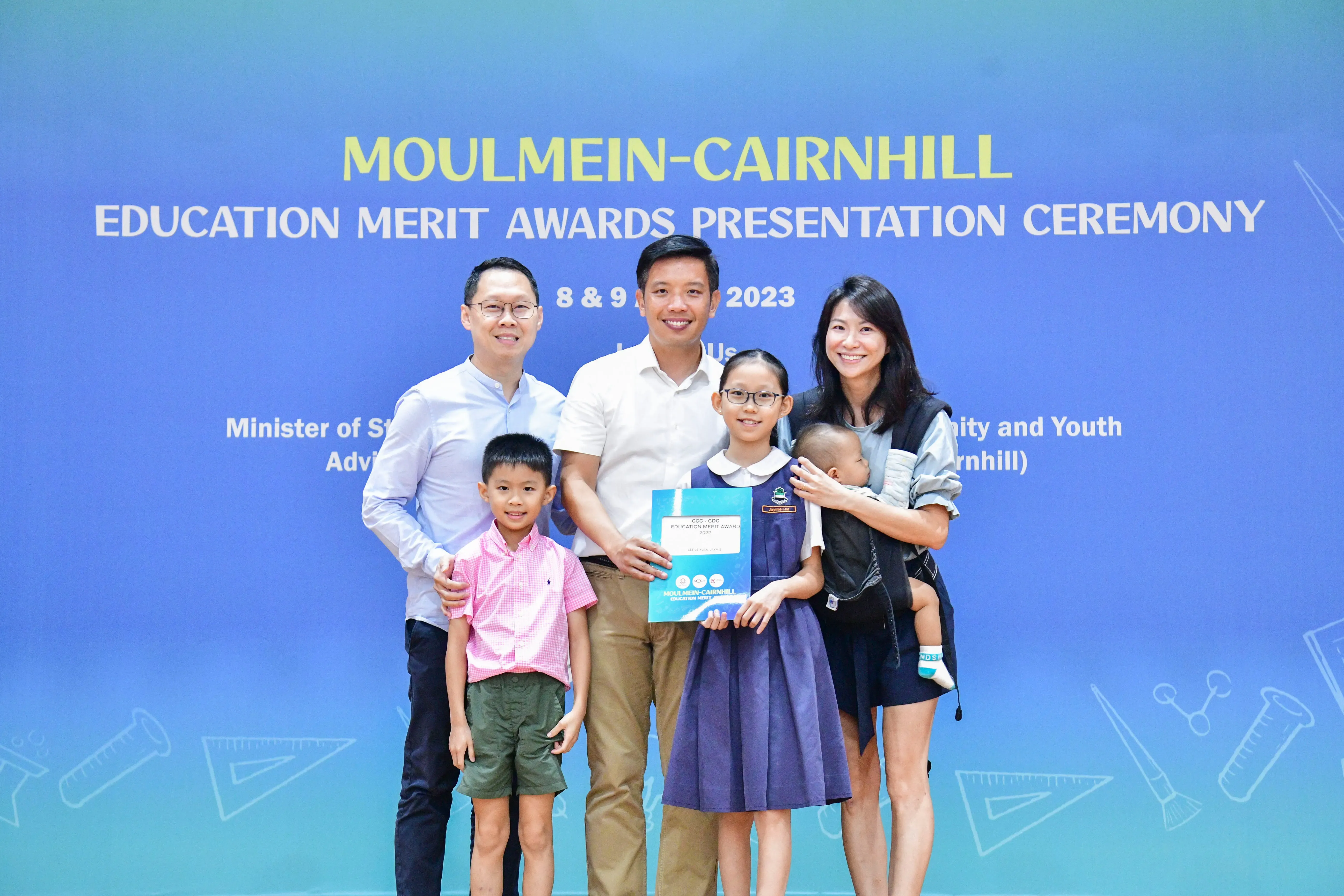 A family poses with an official at the Moulmein-Cairnhill Education Merit Awards Presentation Ceremony 2023.
