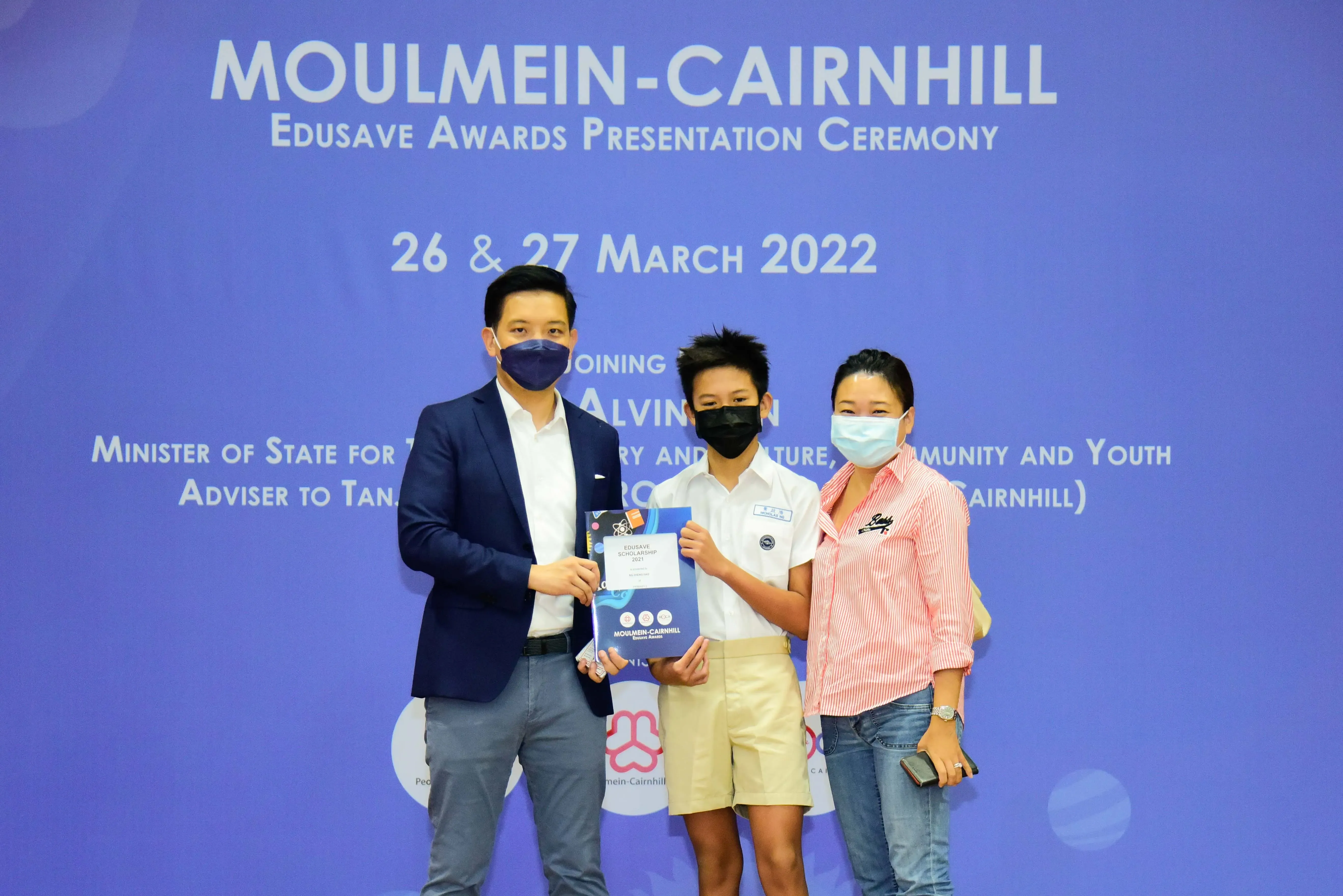 Three masked people pose at the Moulmein-Cairnhill Edusave Awards Presentation Ceremony on 26-27 March 2022.