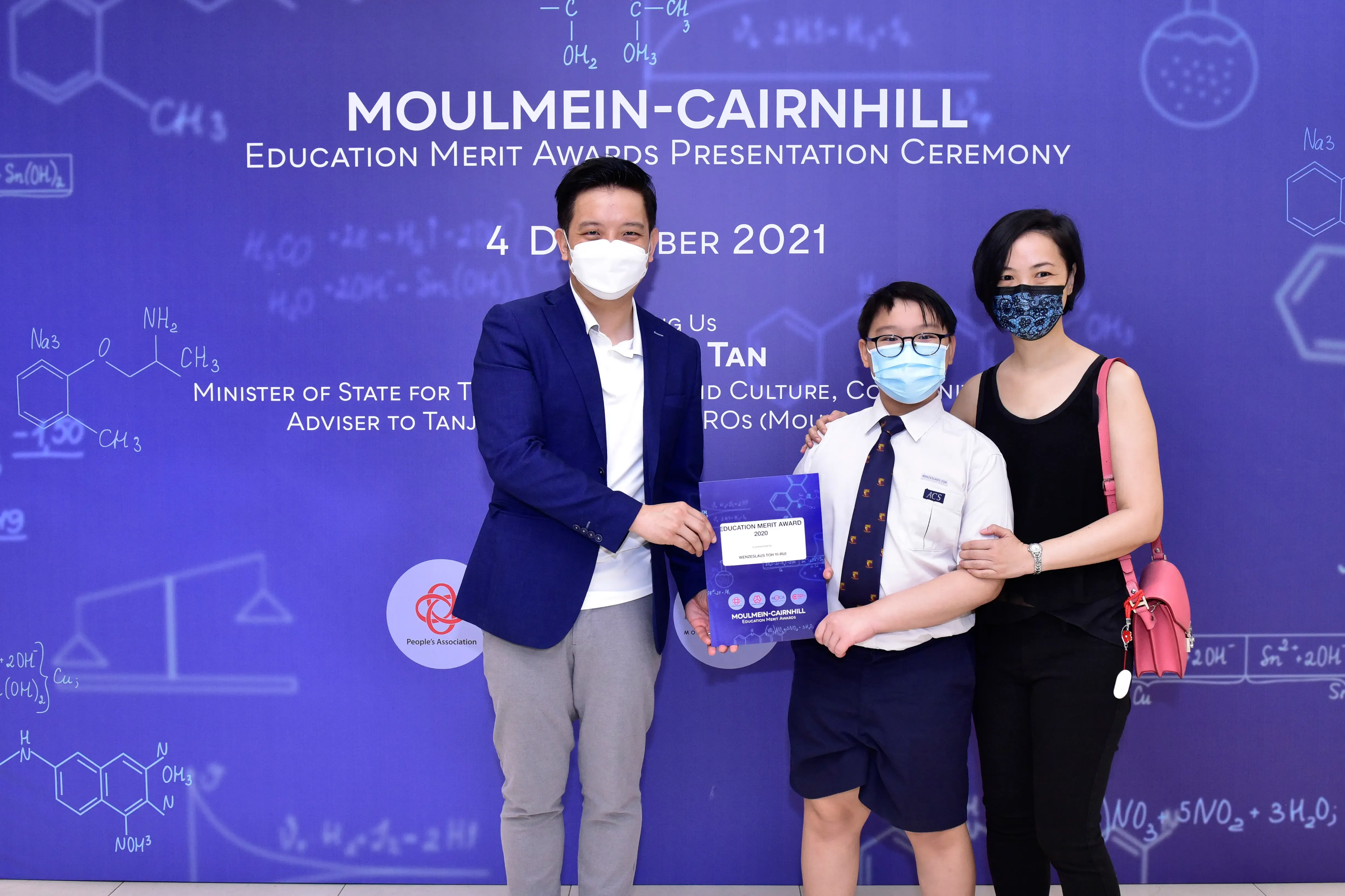 Three masked people pose at the Moulmein-Cairnhill Education Merit Awards Presentation Ceremony, December 2021.