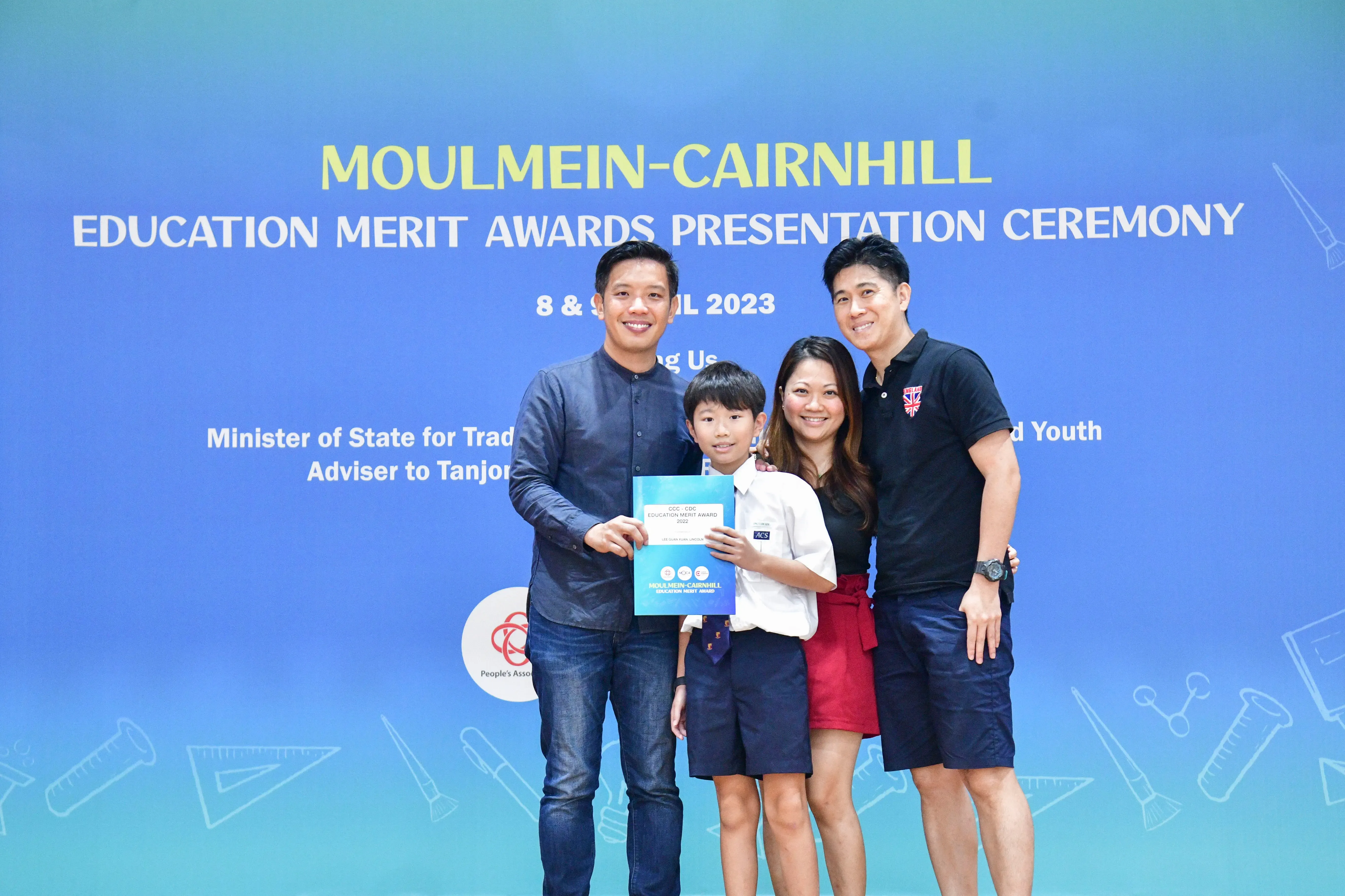 Three adults and a child pose with an award certificate at the Moulmein-Cairnhill Education Merit Awards 2023.
