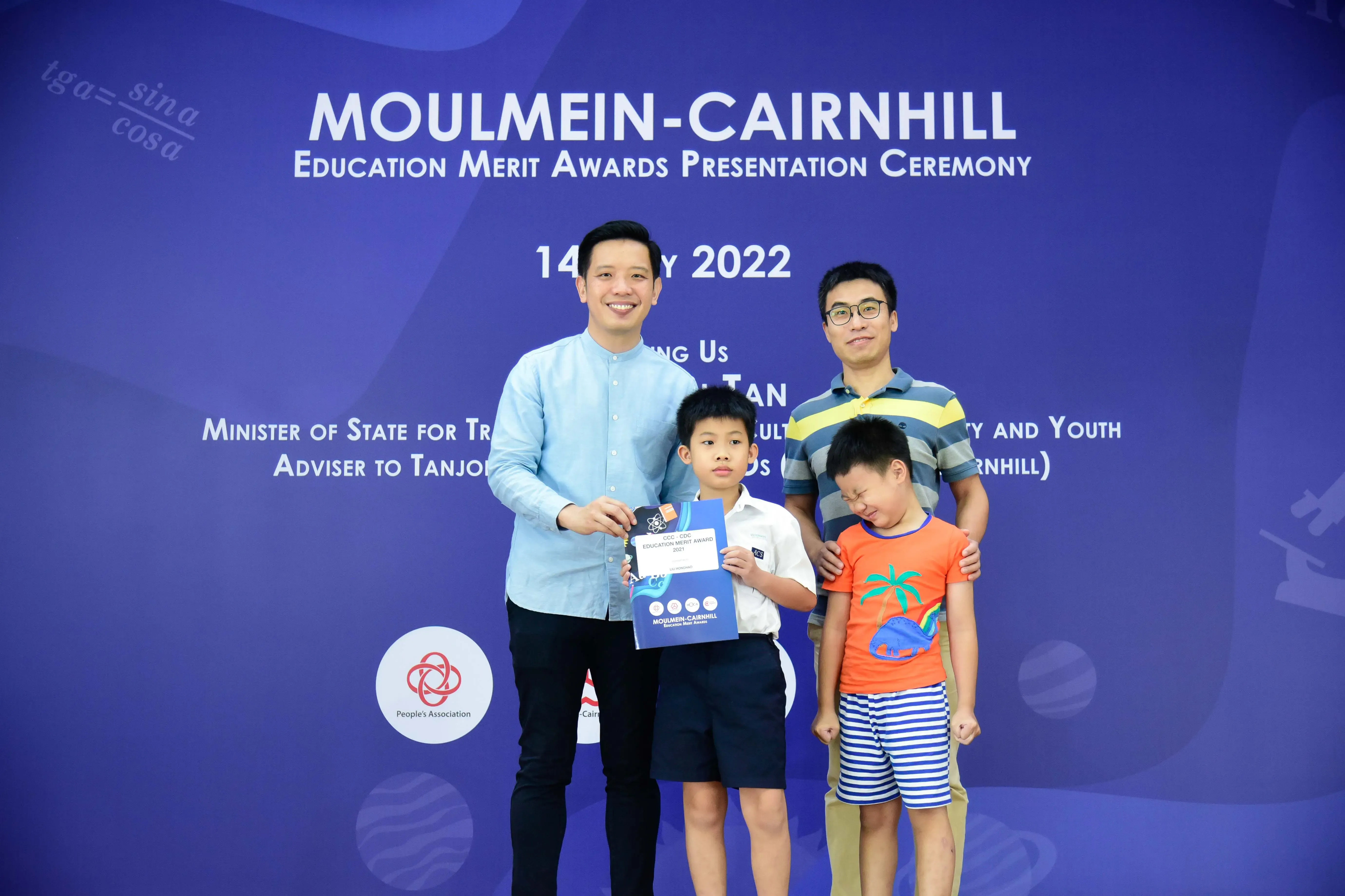 Two men and two boys pose at the Moulmein-Cairnhill Education Merit Awards Presentation Ceremony in 2022.