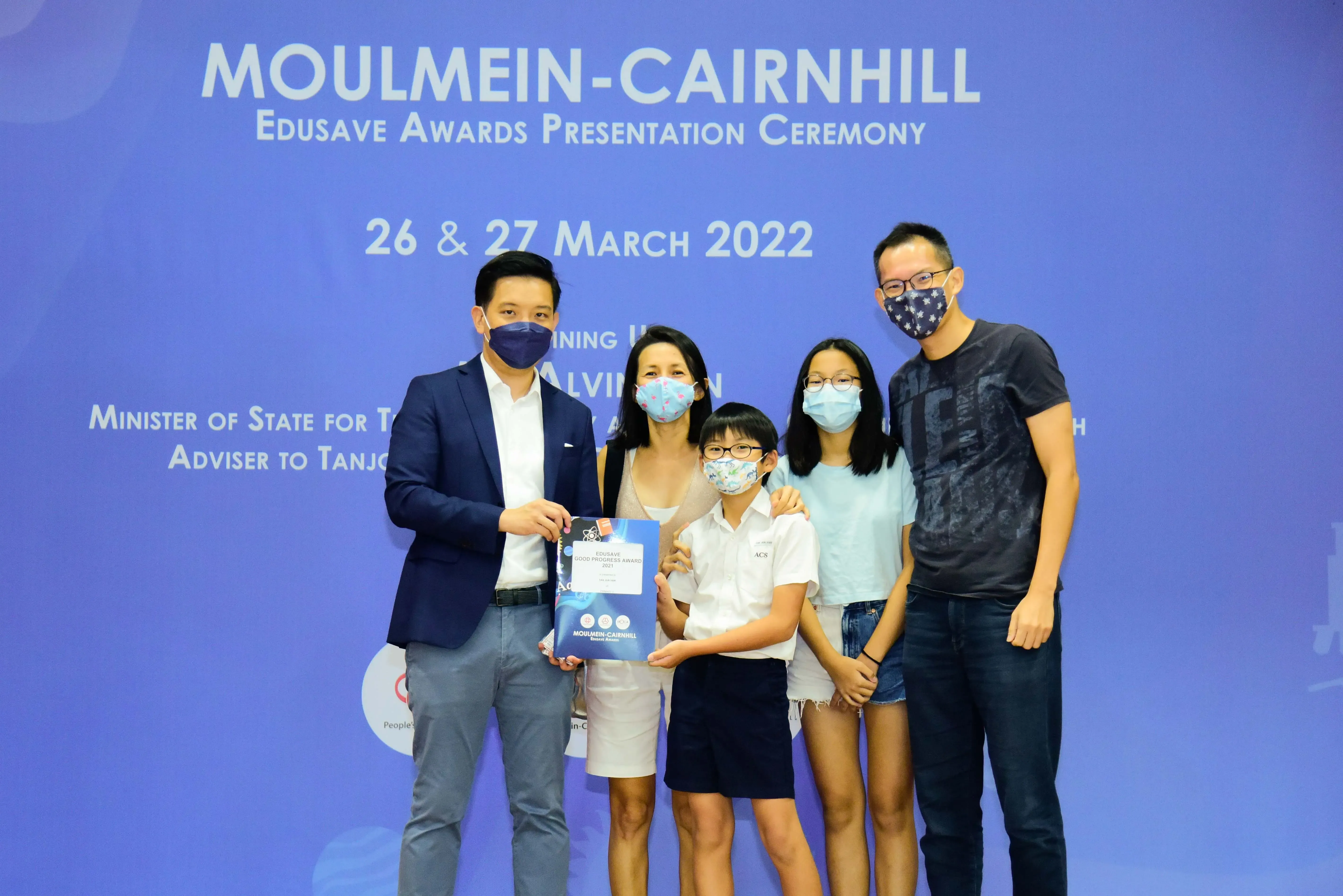 Five masked people pose at the Moulmein-Cairnhill Edusave Awards Presentation Ceremony on 26-27 March 2022.