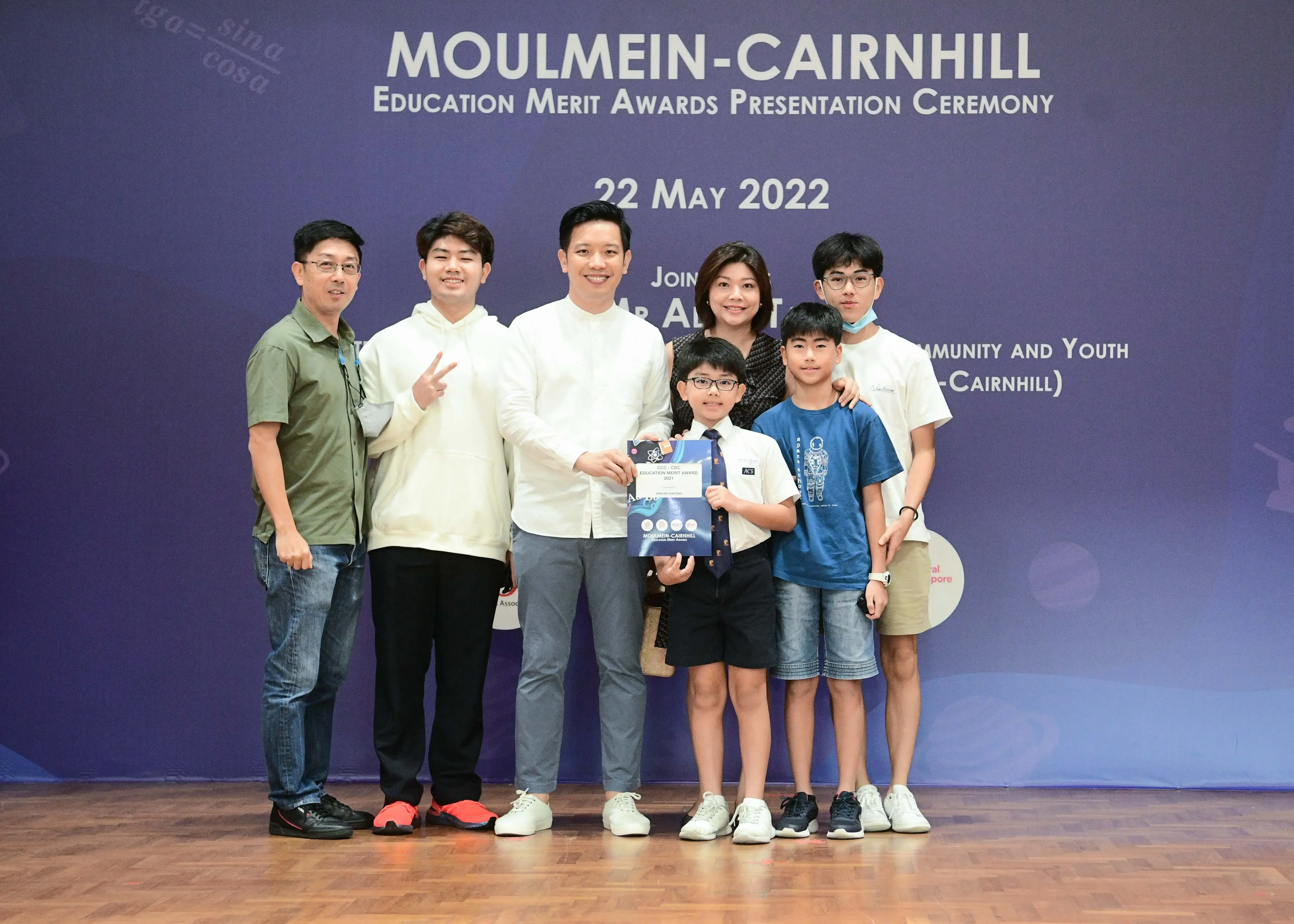 Seven people pose together at the Moulmein-Cairnhill Education Merit Awards Presentation Ceremony on 22 May 2022.