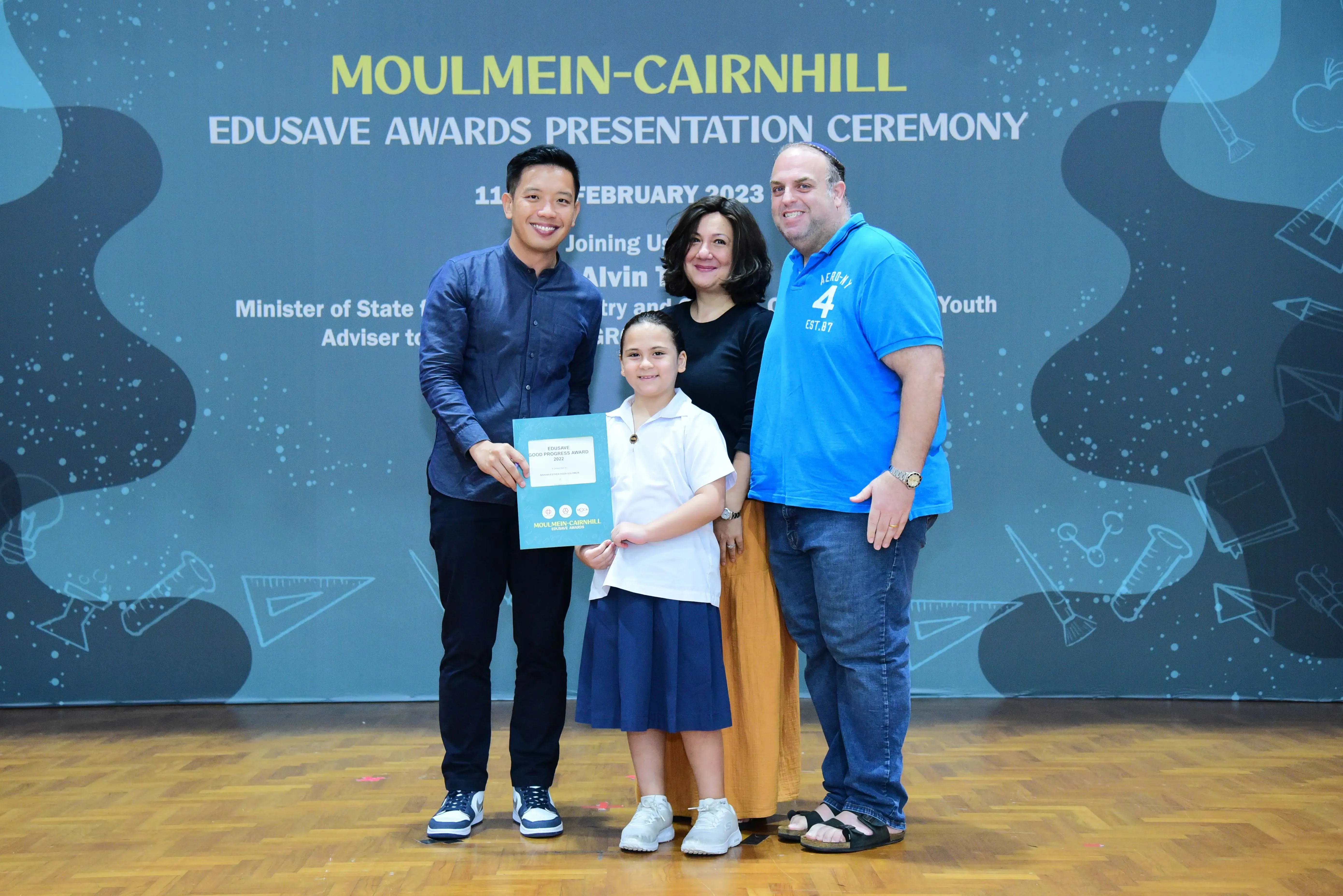 Four people pose with a certificate at the Moulmein-Cairnhill Edusave Awards Presentation Ceremony in February 2023.