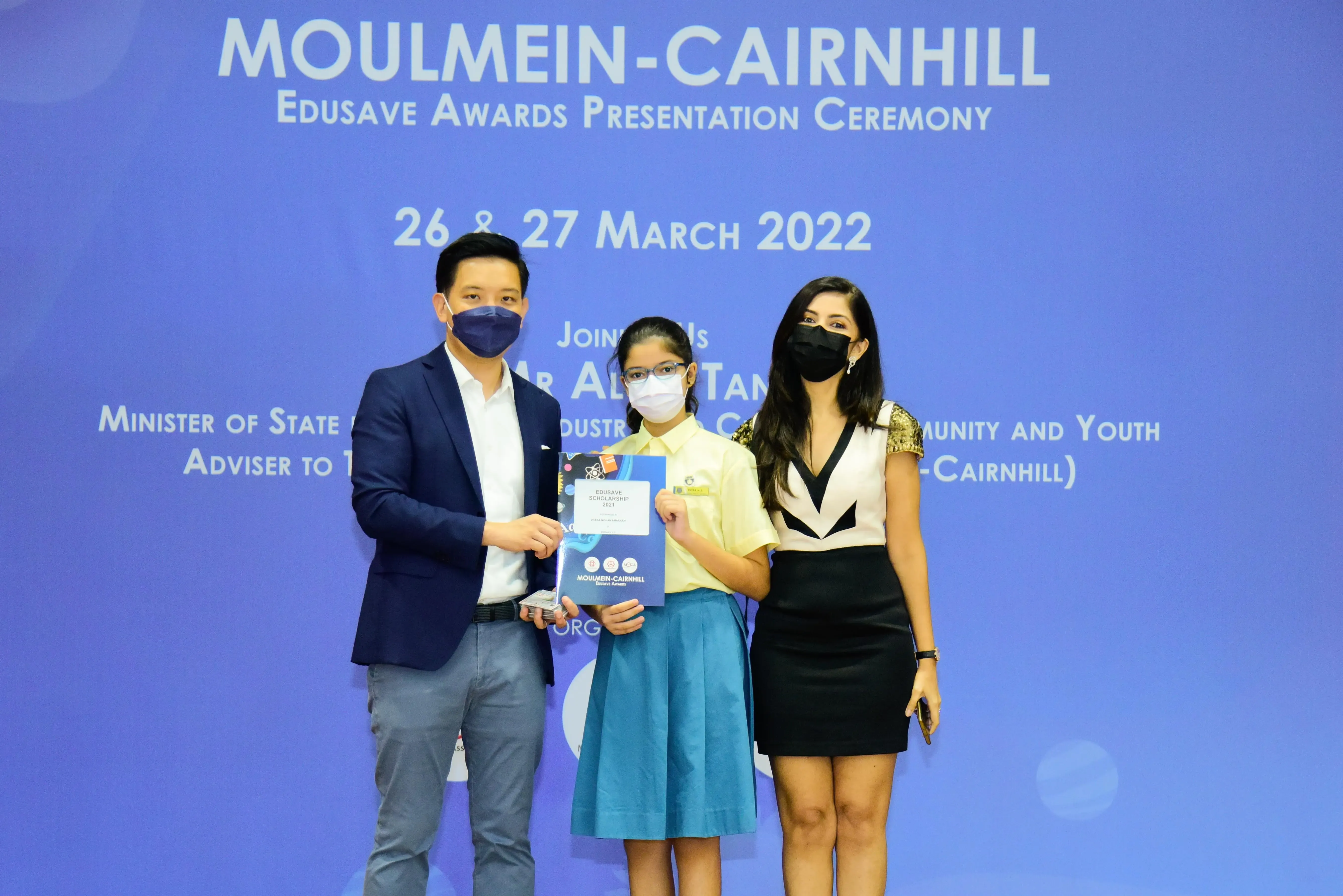 Three masked people pose at the Moulmein-Cairnhill Edusave Awards Presentation Ceremony on 26-27 March 2022.