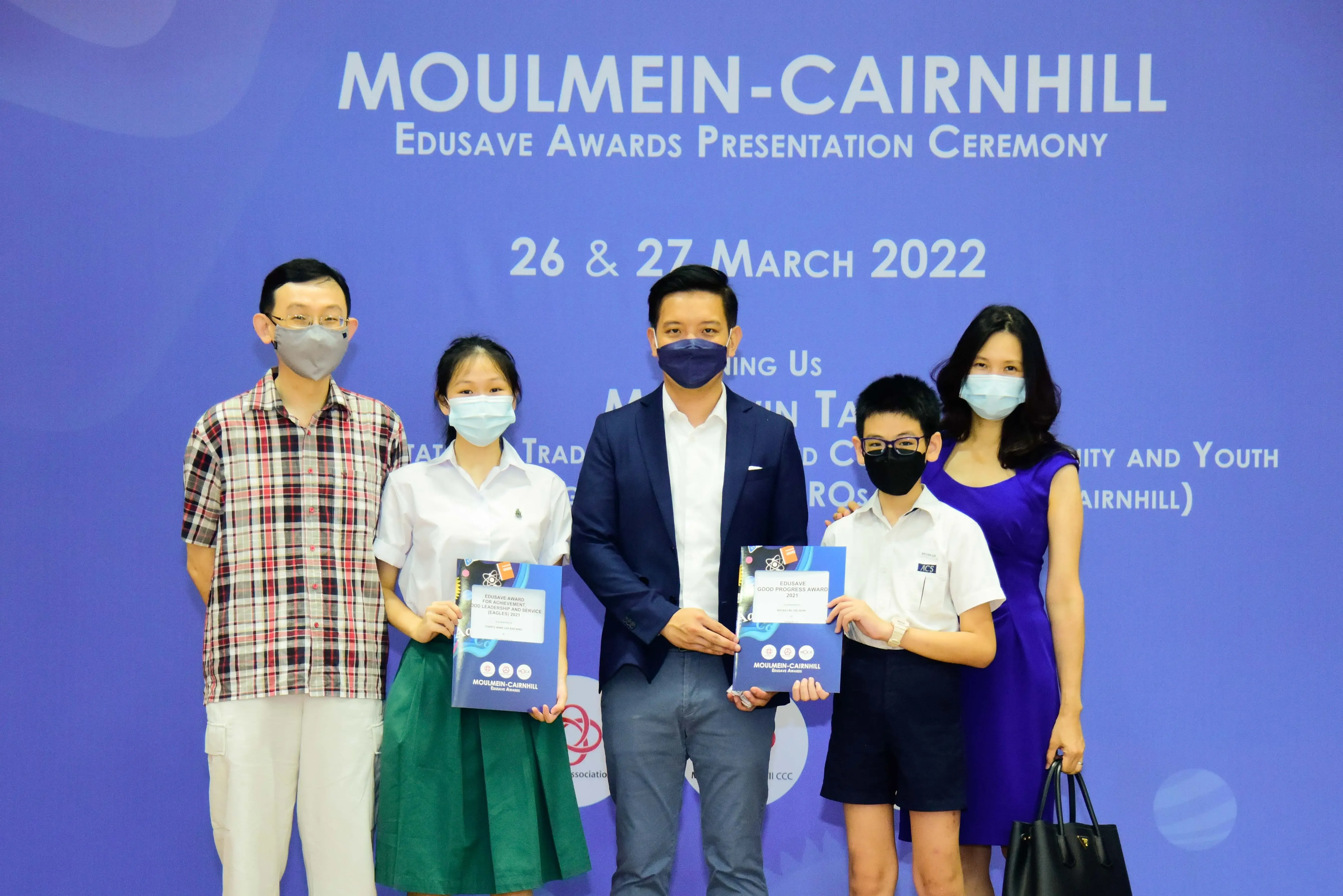 Five masked people pose at the Moulmein-Cairnhill Edusave Awards Presentation Ceremony on 26-27 March 2022.
